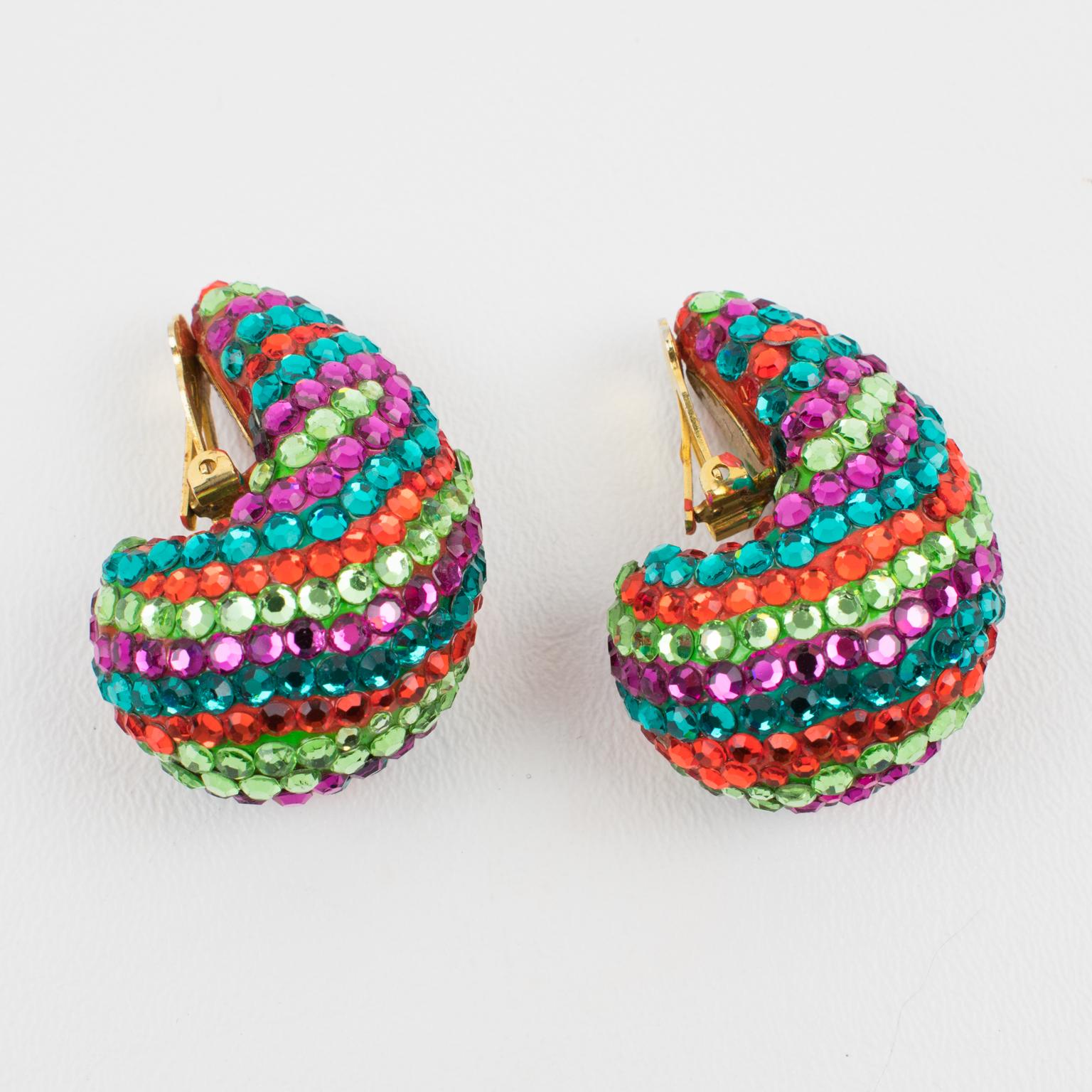 Richard Kerr created these sophisticated clip-on earrings in the 1980s. They are composed of his trademark pave crystals and have a nautilus shape. They are framed in red resin and adorned with multicolor crystal rhinestones. The colors of the