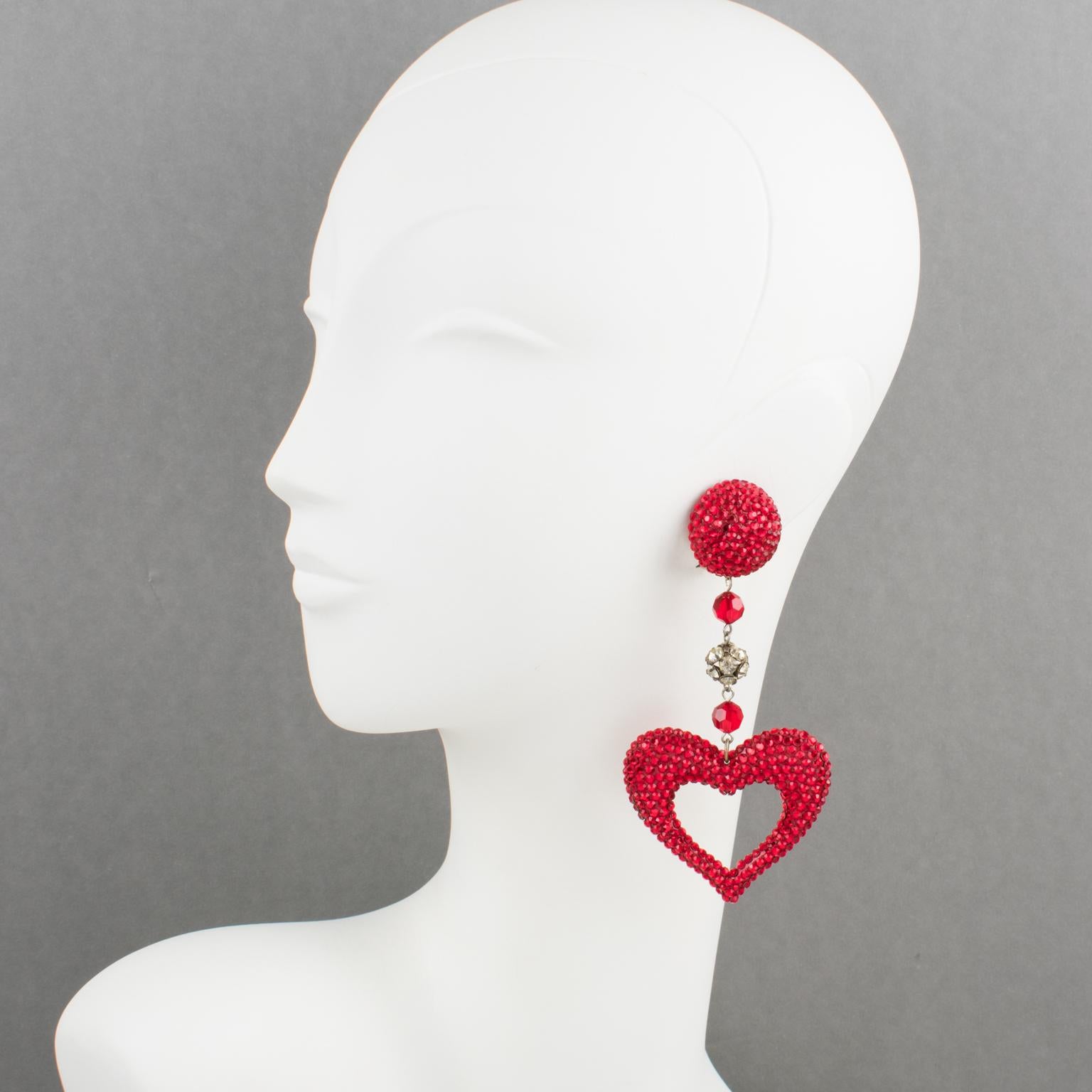 These gorgeous statement clip-on earrings were designed by Richard Kerr in the 1980s. They are made up of his signature pave rhinestones. Featuring dangle extra-long shape with stylized carved and see-thru heart design all covered with crystal