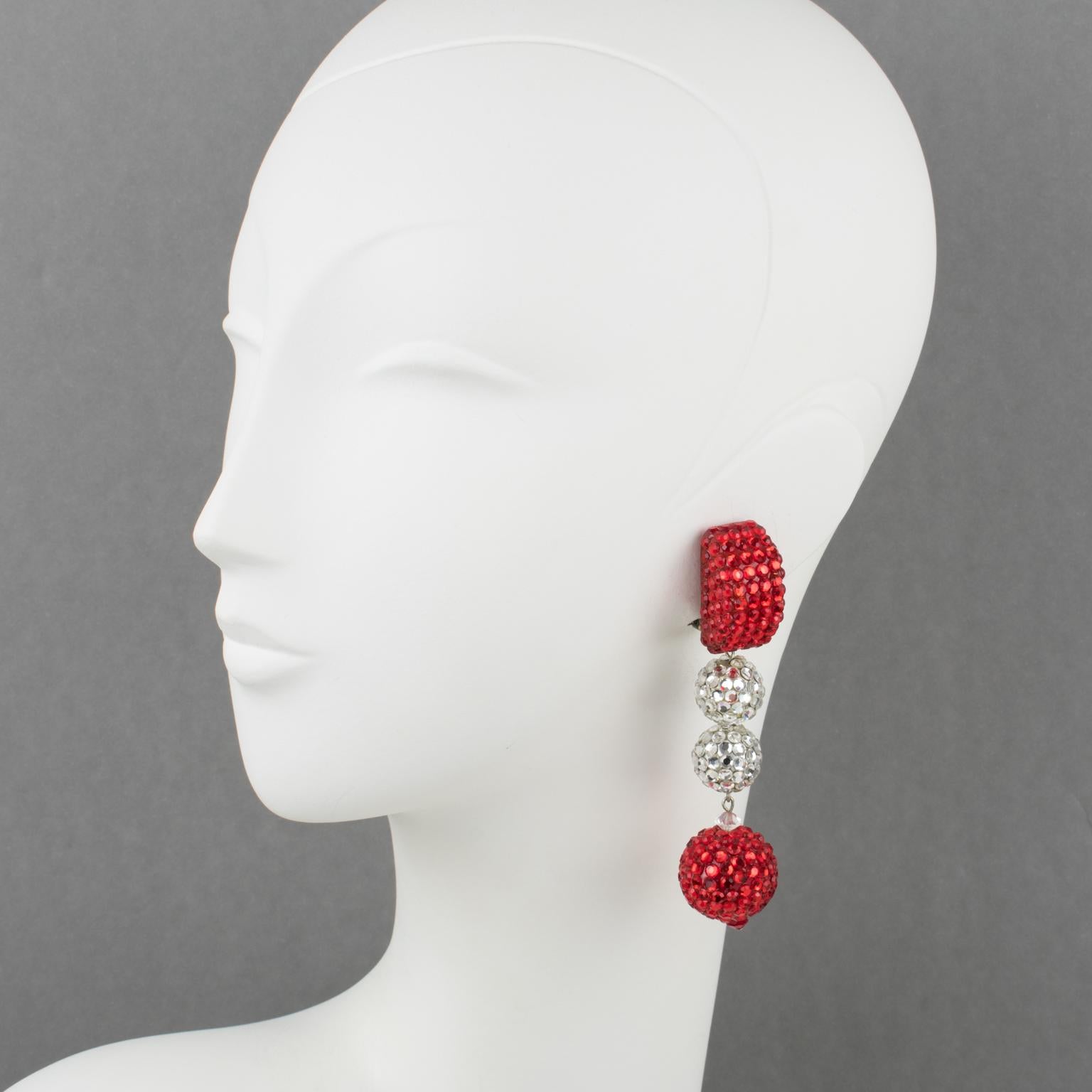 Richard Kerr designed those sophisticated statement clip-on earrings in the 1980s. The brand signature rhinestones paved design features a dangle extra-long drop shape, all covered with crystal rhinestones. 
Bright glittering white silver and ruby