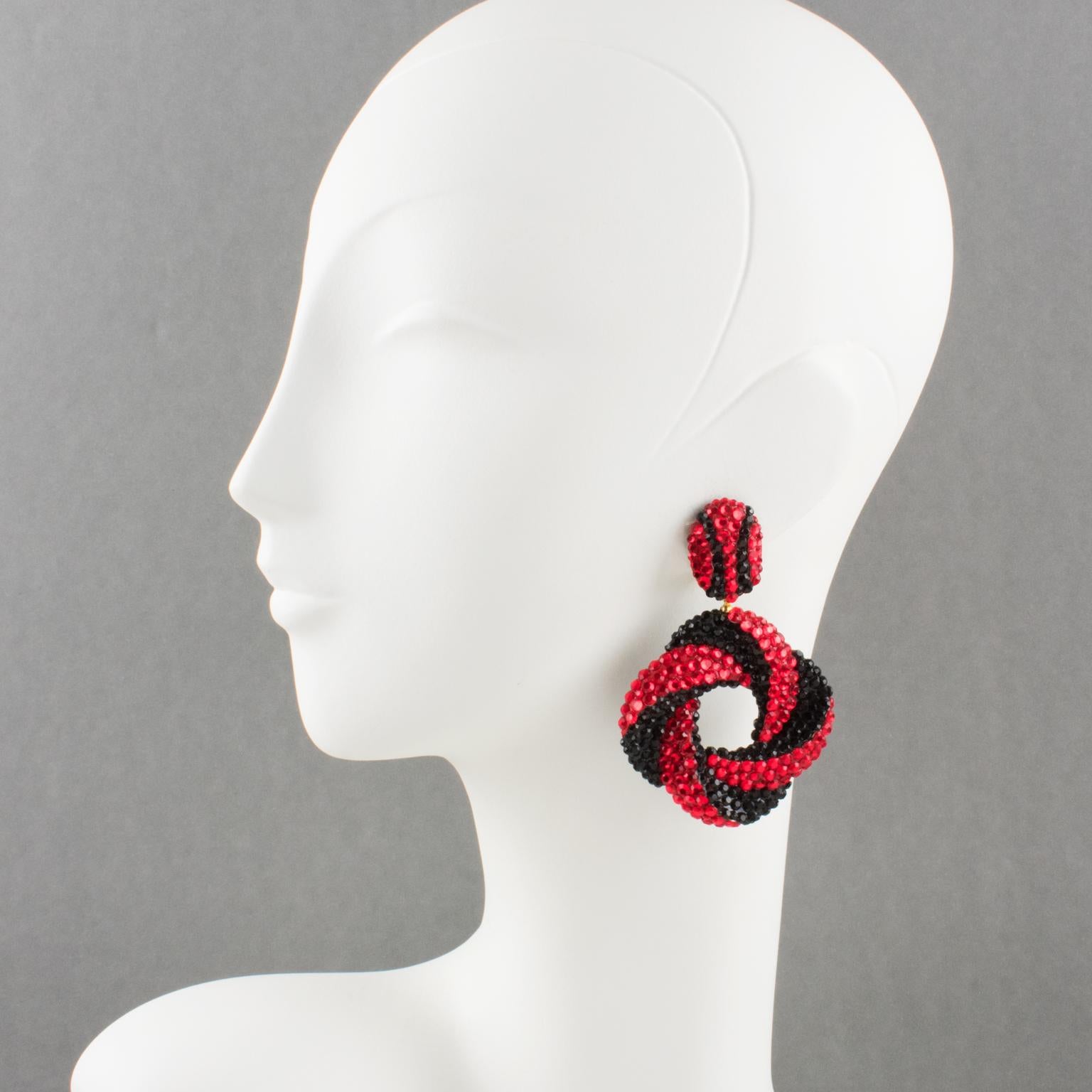 Richard Kerr designed these adorable statement clip-on earrings in the 1980s. They are made up of his signature pave rhinestones. The pieces feature a dimensional donut shape with a swirling design all covered with red and black luminous crystal
