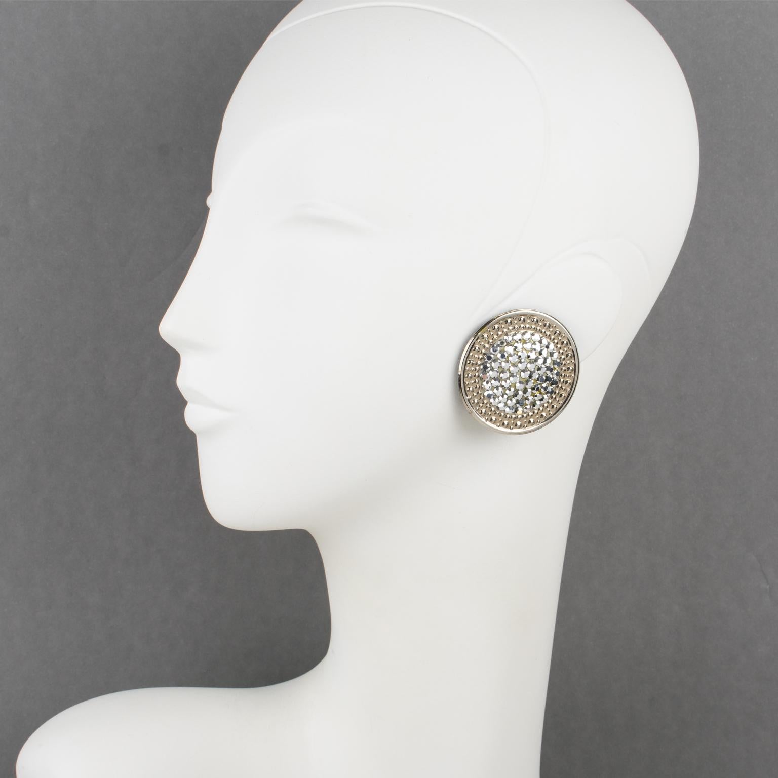 Impressive statement clip-on earrings designed by Richard Kerr in the 1980s. They are made of his signature pave rhinestones. These pieces feature a large rounded silvered metal framing with texture, topped with silver crystal rhinestones. Brand tag