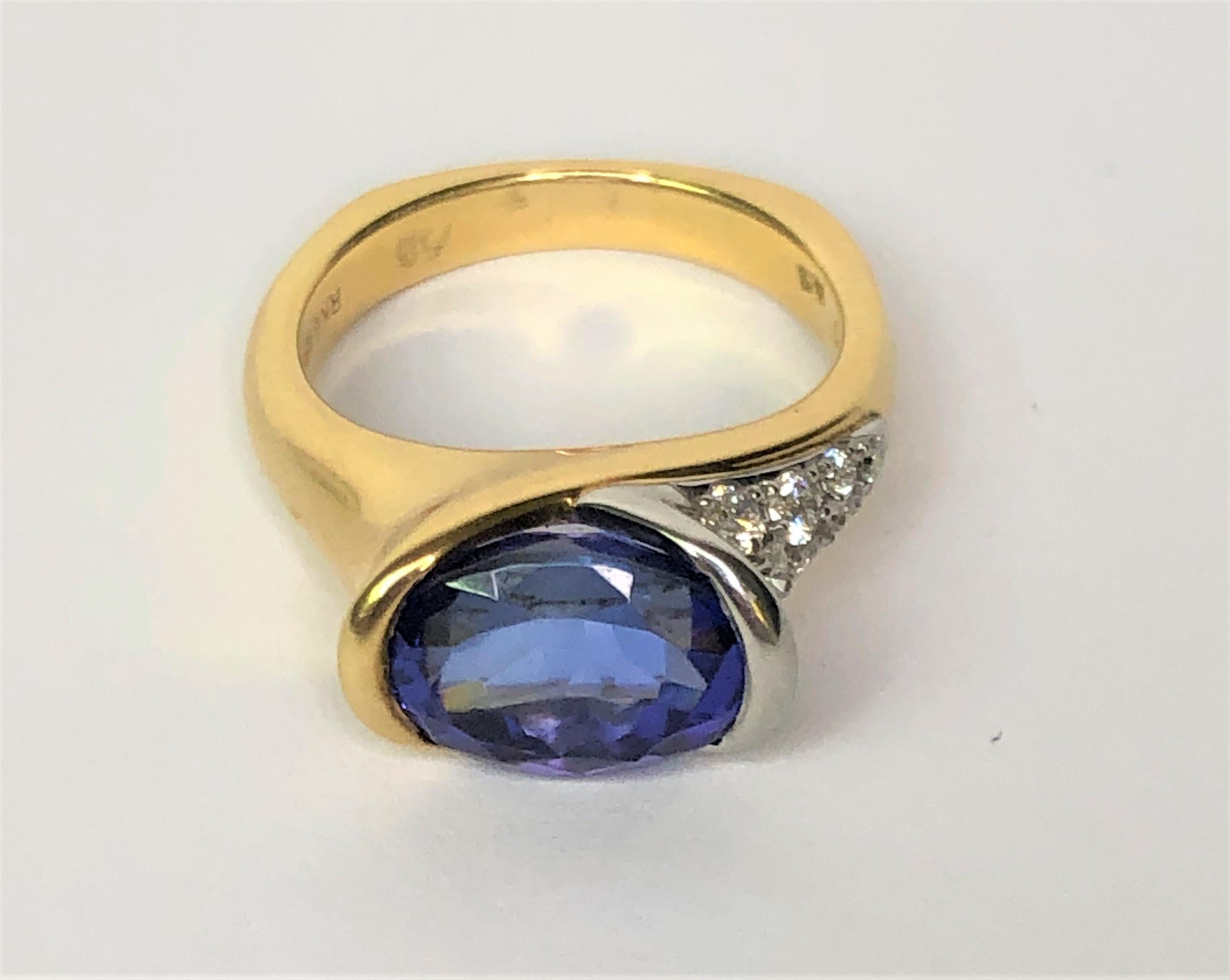 Simple, classic and beautiful - true to his craftmanship!  This special Richard Krementz ring is amazing!!
18 karat yellow gold and platinum.
Center stone is a 4.8 carat oval cut tanzanite in a gold and platinum head.
Platinum side of shoulder has 8