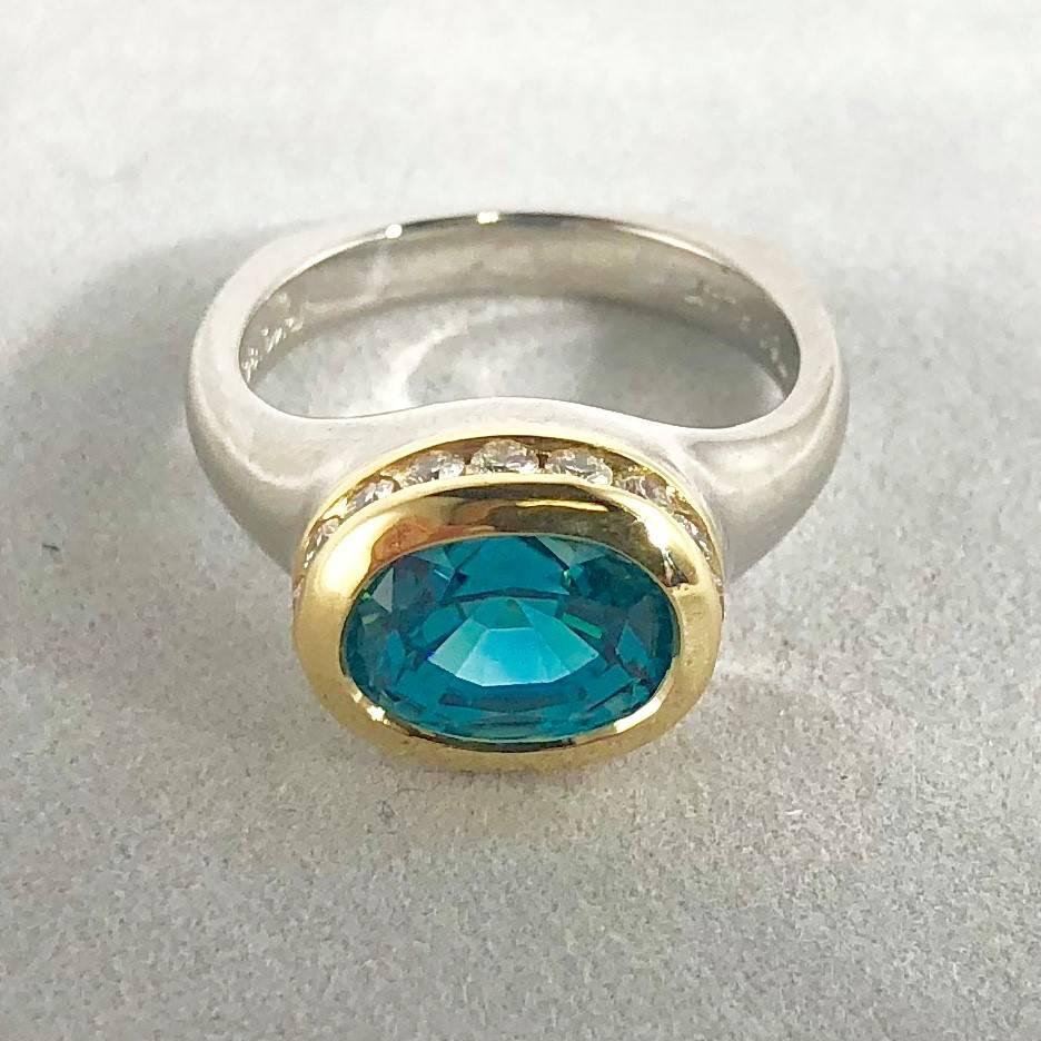 Richard Krementz Gemstones  Platinum, 18 karat and 5.48 carat Blue Zircon and Diamond cocktail ring. This piece is created in a two tone Platinum and 18 karat yellow gold weighing 11.7 grams/ 7.5 dwt. The center stone is an Oval cut Blue Zircon