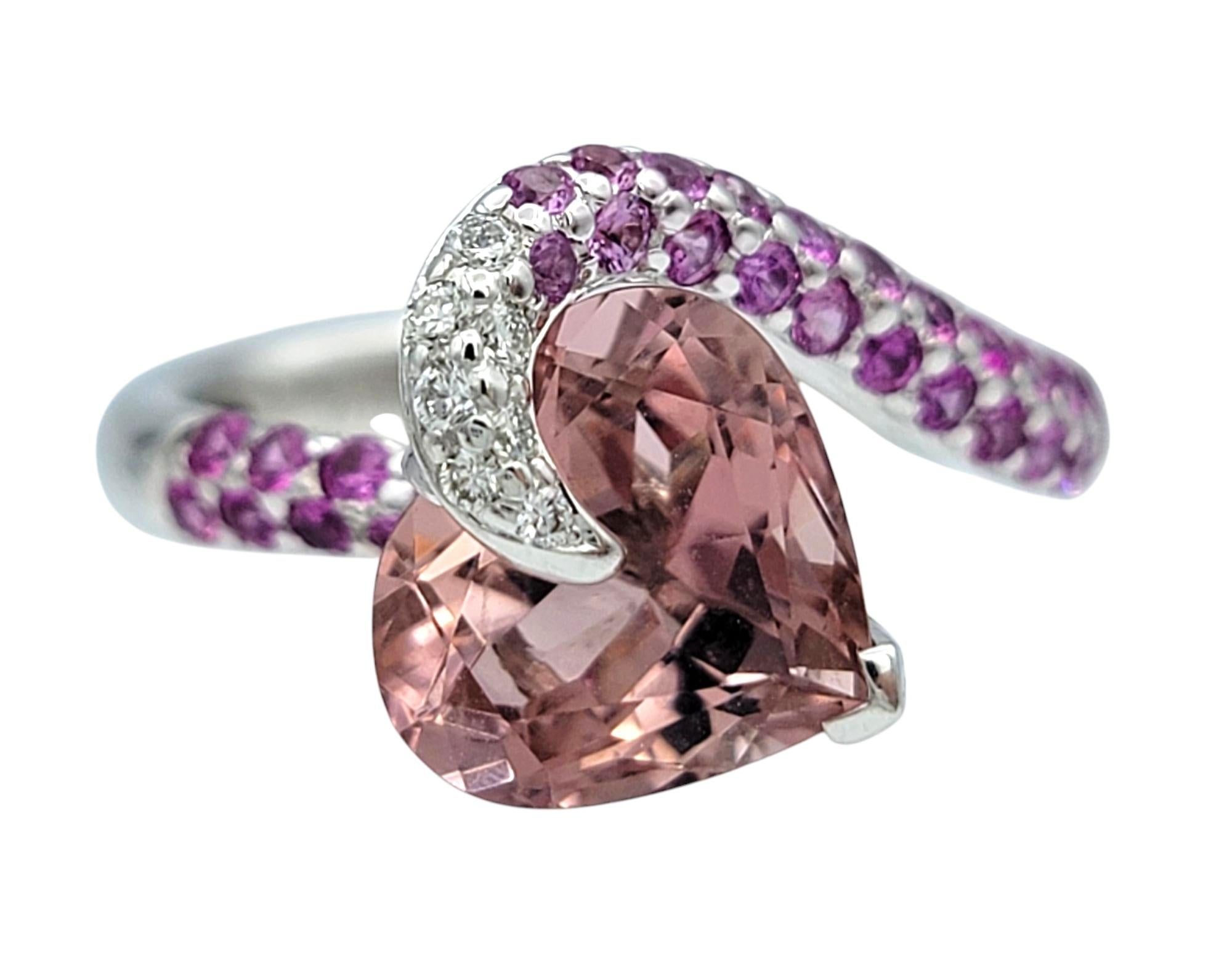 Ring Size: 6.25 

This incredible ring by Richard Krementz showcases a romantic heart-cut pink tourmaline set at the center, elevated by complementary tones and textures. The soft hue of the tourmaline is echoed by a sweep of round pink sapphires