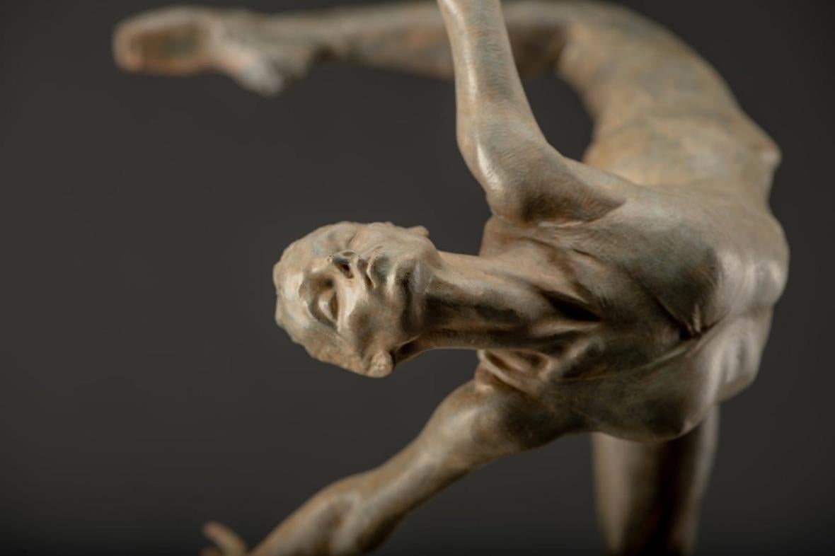 In “Flight in Attitude”, the clean lines of the dancer’s form suggest purity and strength. With fingers elegantly outstretched and back arched, she is the embodiment of athletic perfection and artistic refinement. Soaring with the effortless grace