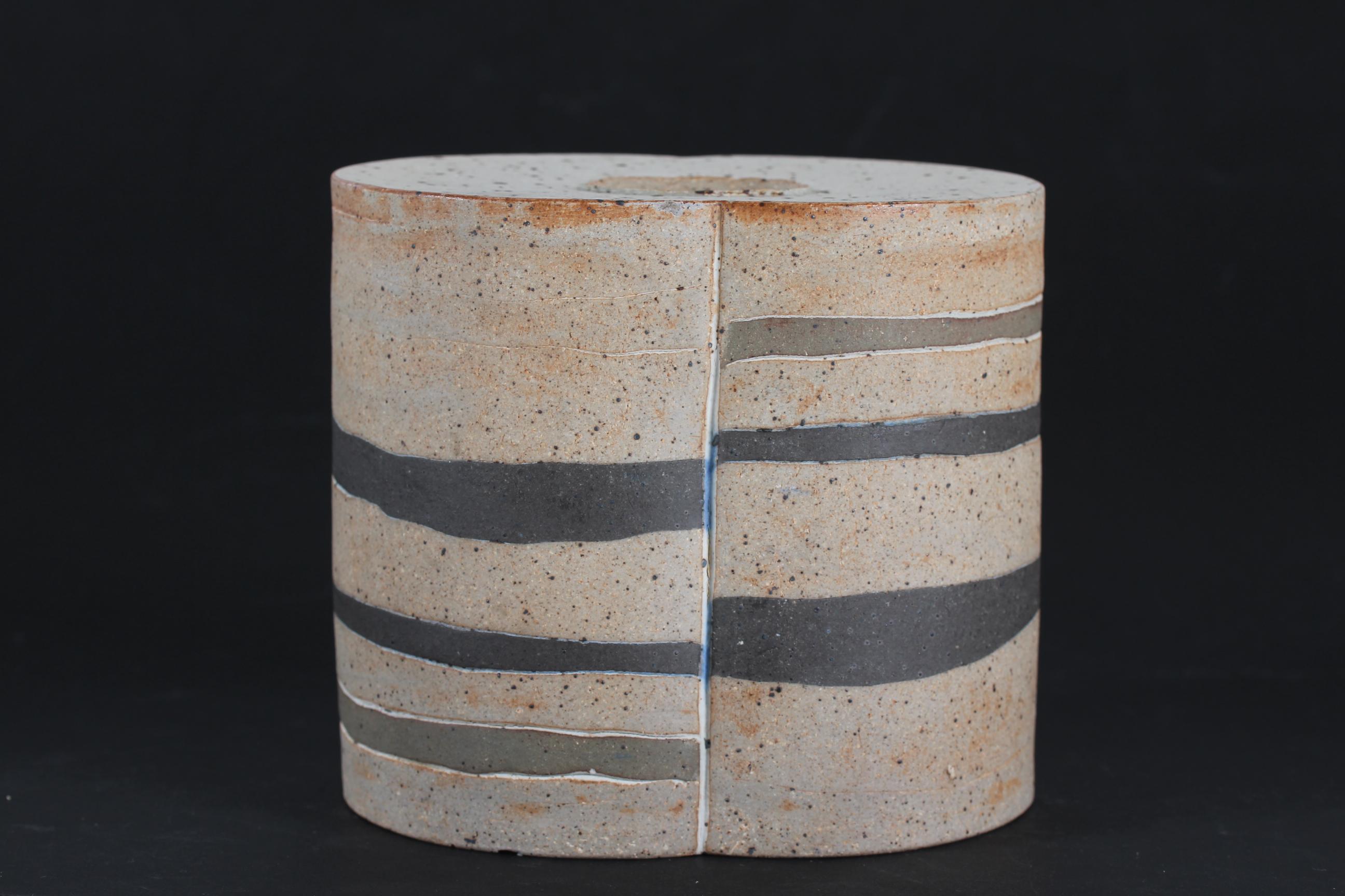 Rustic and sculptural stoneware vase made by the German-Swedish-Danish ceramist Richard Manz (1933-1999). The husband of the Danish ceramist Bodil Manz.
The unglazed vase has a matte black/grey decoration of horizontal stripes.

Stamped Richard