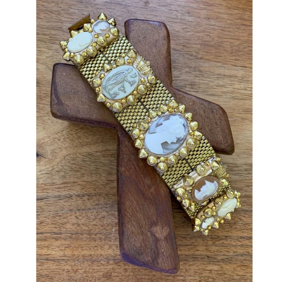Richard Minadeo brass link double-wide bracelet featuring vintage coral and ivory portrait and Roman soldier cameos inset in gold-tone resin with gold studs.

Famous in the ’80s for his handmade, one of a kind, and extremely personal jewelry and