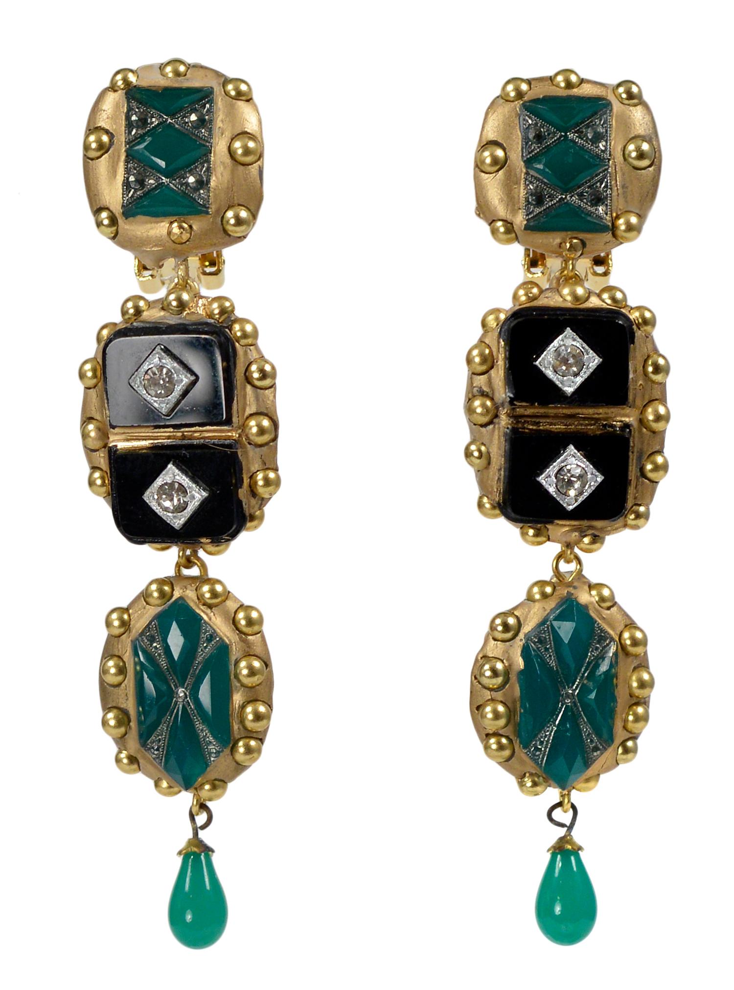 Richard Minadeo emerald green, black onyx, and jade-colored Art Deco-inspired statement earrings featuring clear rhinestone diamond shape insets, jade drops, and clip backs set in gold resin with studs. 

We are pleased to announce Resurrected: