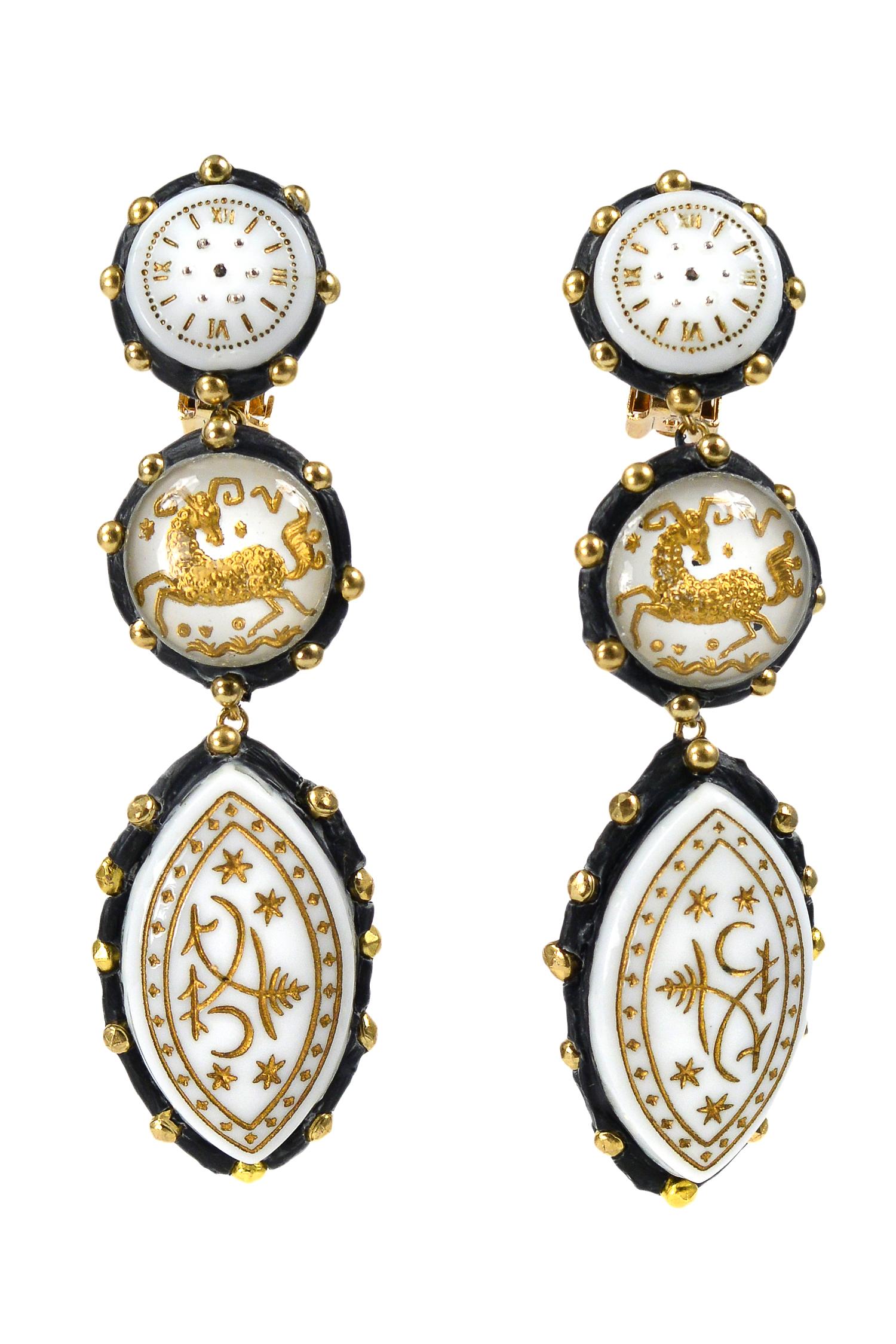 Handmade one-of-a-kind Richard Minadeo drop clip earrings with white enamel and gold etched zodiac and Capricorn symbols set in onyx resin with gold-tone studs.

We are pleased to announce Resurrected: Richard Minadeo and the art of Memento Mori: