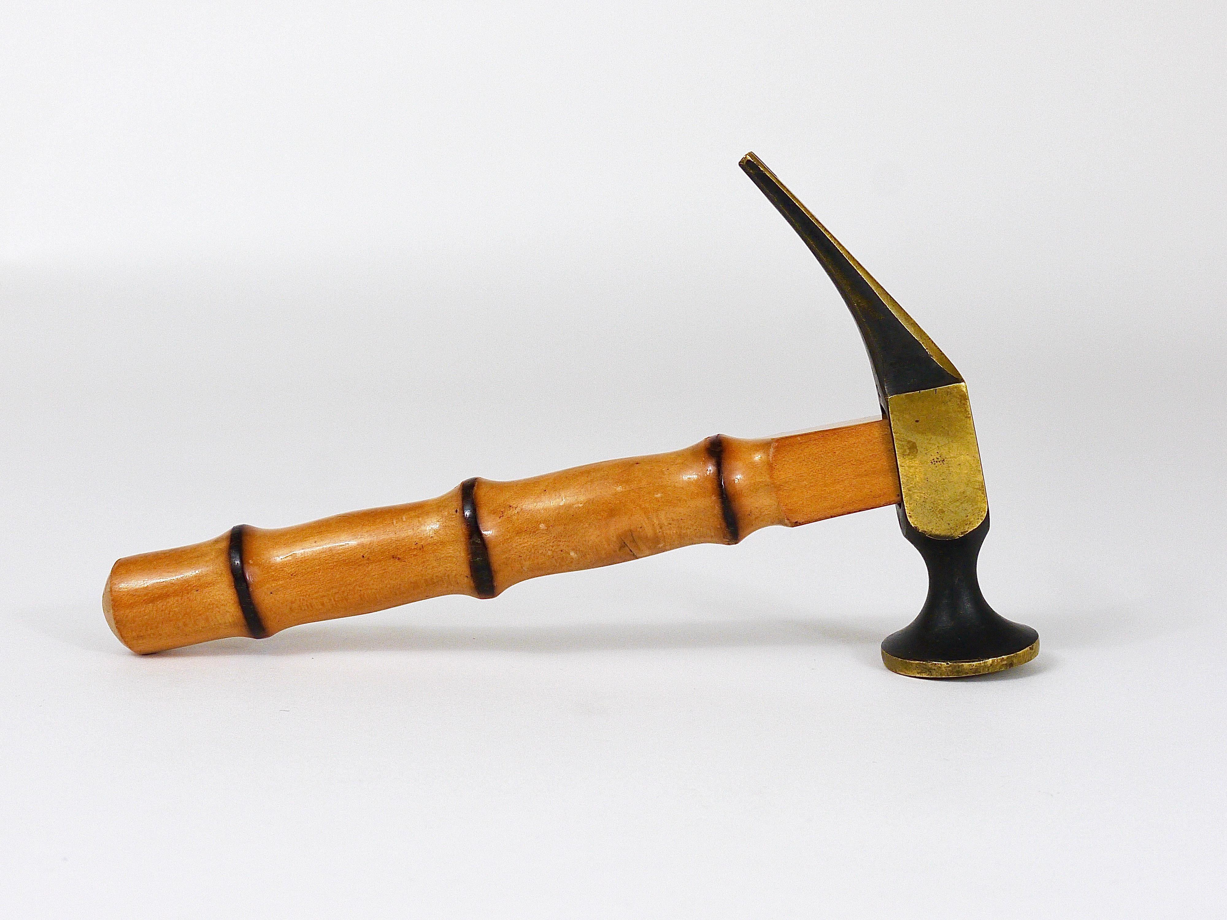 An unusual midcentury bottle opener, cork screw and nut cracker in the shape of a hammer. Made of brass with a nice bamboo handle. Executed in the 1950s by Richard Rohac in Austria. Fully marked. In good condition with nice patina. An outstanding