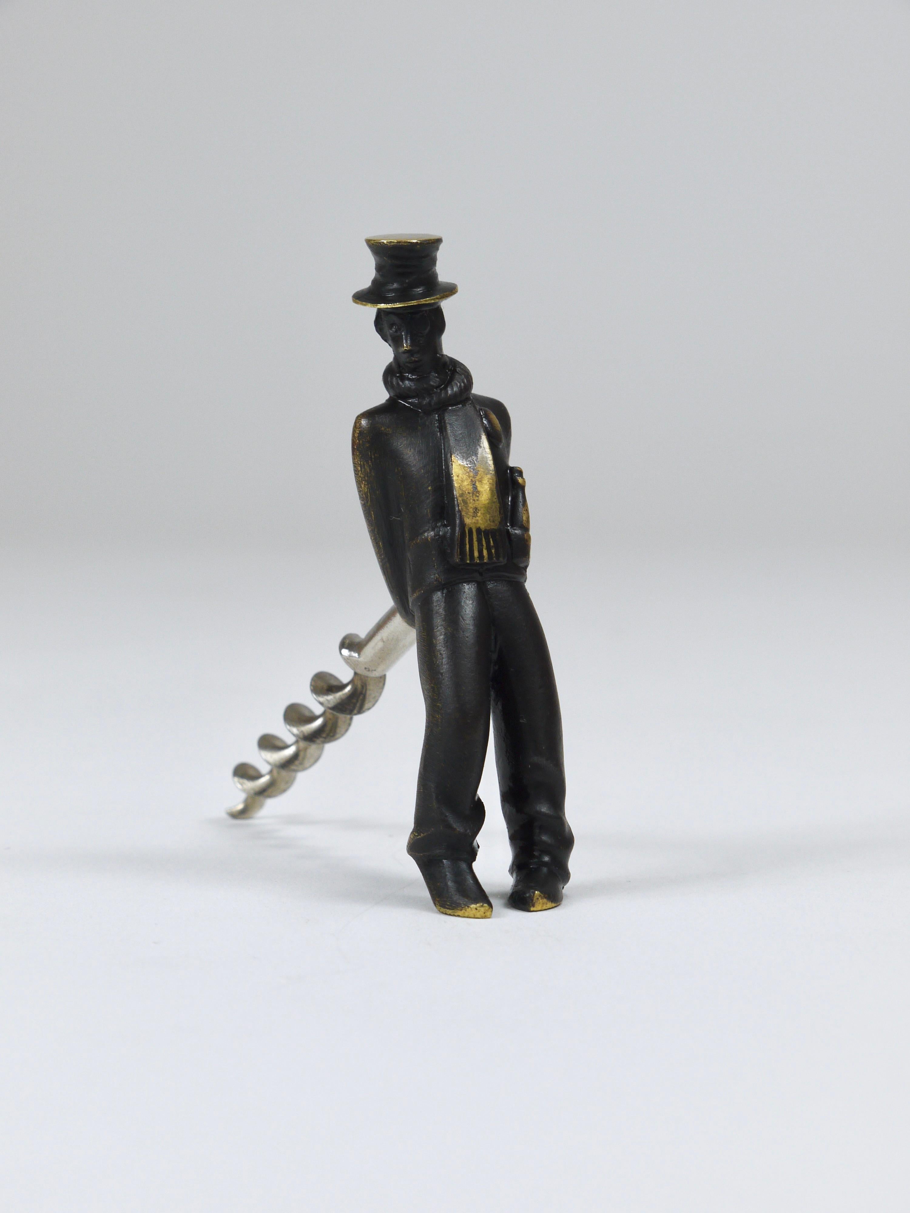 A Mid-Century bottle opener from the 1950s by Richard Rohac, Vienna, Austria. Made of blackened brass, it depicts a leaning, presumably tipsy gentleman wearing a top hat and scarf, with a  bottle of Champagne tucked into his coat pocket — he looks
