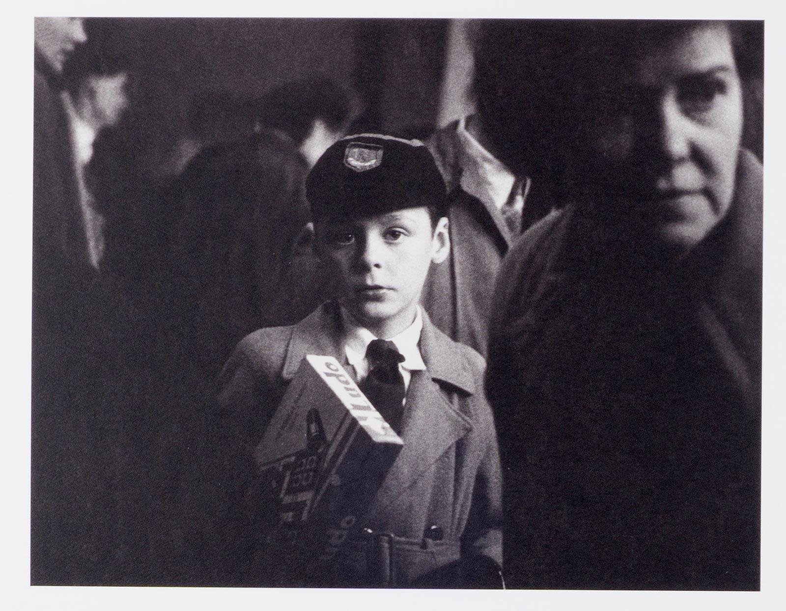 Young Lad ( eindringliches Porträt eines jungen Jungen auf einer überfüllten Londoner Straße) (Schwarz), Black and White Photograph, von Richard Sadler