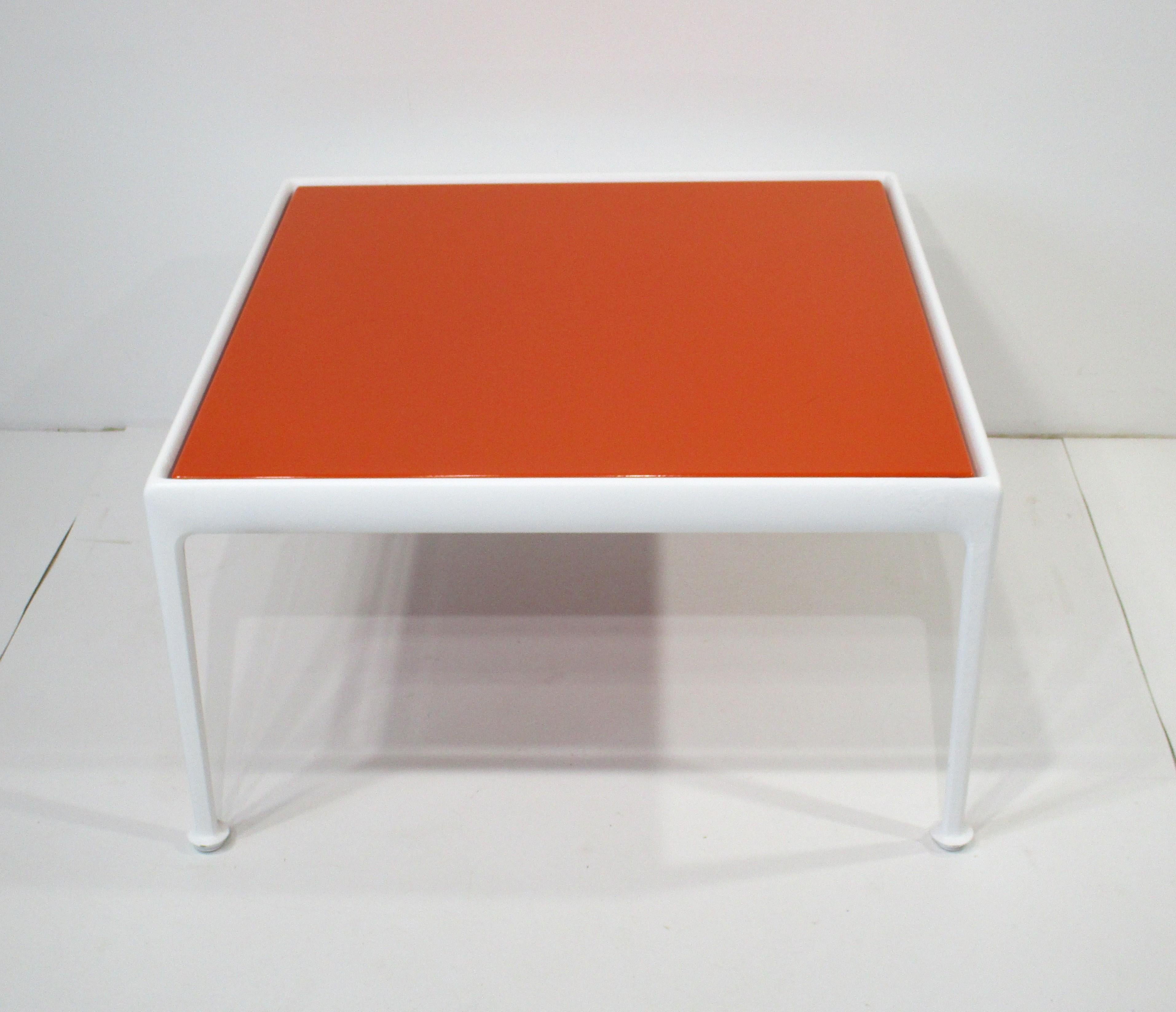 Une superbe table basse d'extérieur ou d'intérieur du milieu du siècle de la Collection Leisure fabriquée par Knoll . Whiting : plateau en métal émaillé orange vif reposant sur un socle en aluminium moulé peint en blanc avec des pieds en forme de