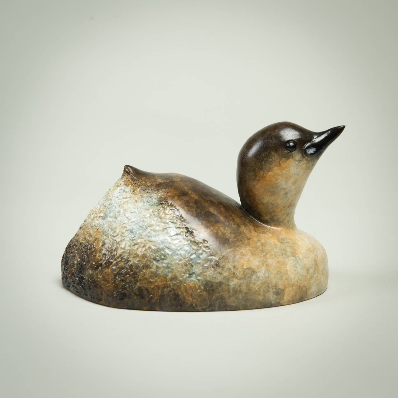 'Dabchick' is a solid Bronze sculpture with a stunning patination. Richard Smith's ability to convey so much character with such simple lines is a testament to the knowledge and love the artist has of the animals he sculpts.

 Richard J. Smith was