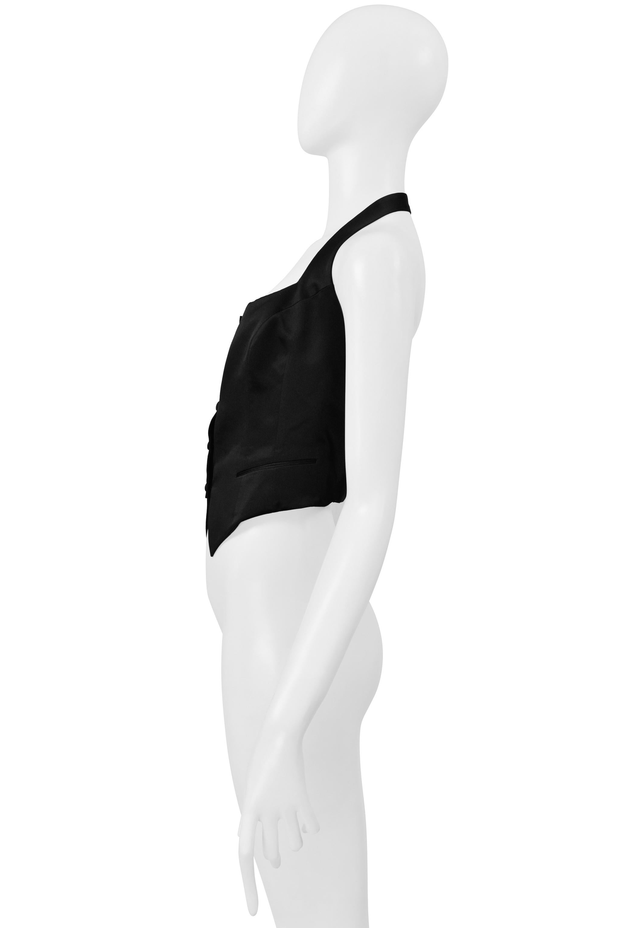 Resurrection Vintage è lieta di presentarti un top con scollo ad aletta in raso nero di Richard Tyler, caratterizzato da scollatura dritta, senza maniche, bottoni frontali e taglio corto.  

Richard Tyler 
Taglia: Senza etichetta, veste come una