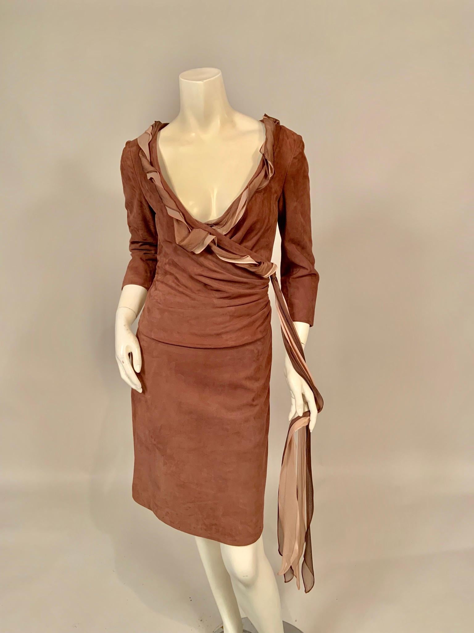This is a most glamorous suede dress, with a low neckline and a faux wrap design edged with silk chiffon with long chiffon streamers. The dress has three quarter sleeves and a right side invisible zipper. It is fully lined in pale pink silk