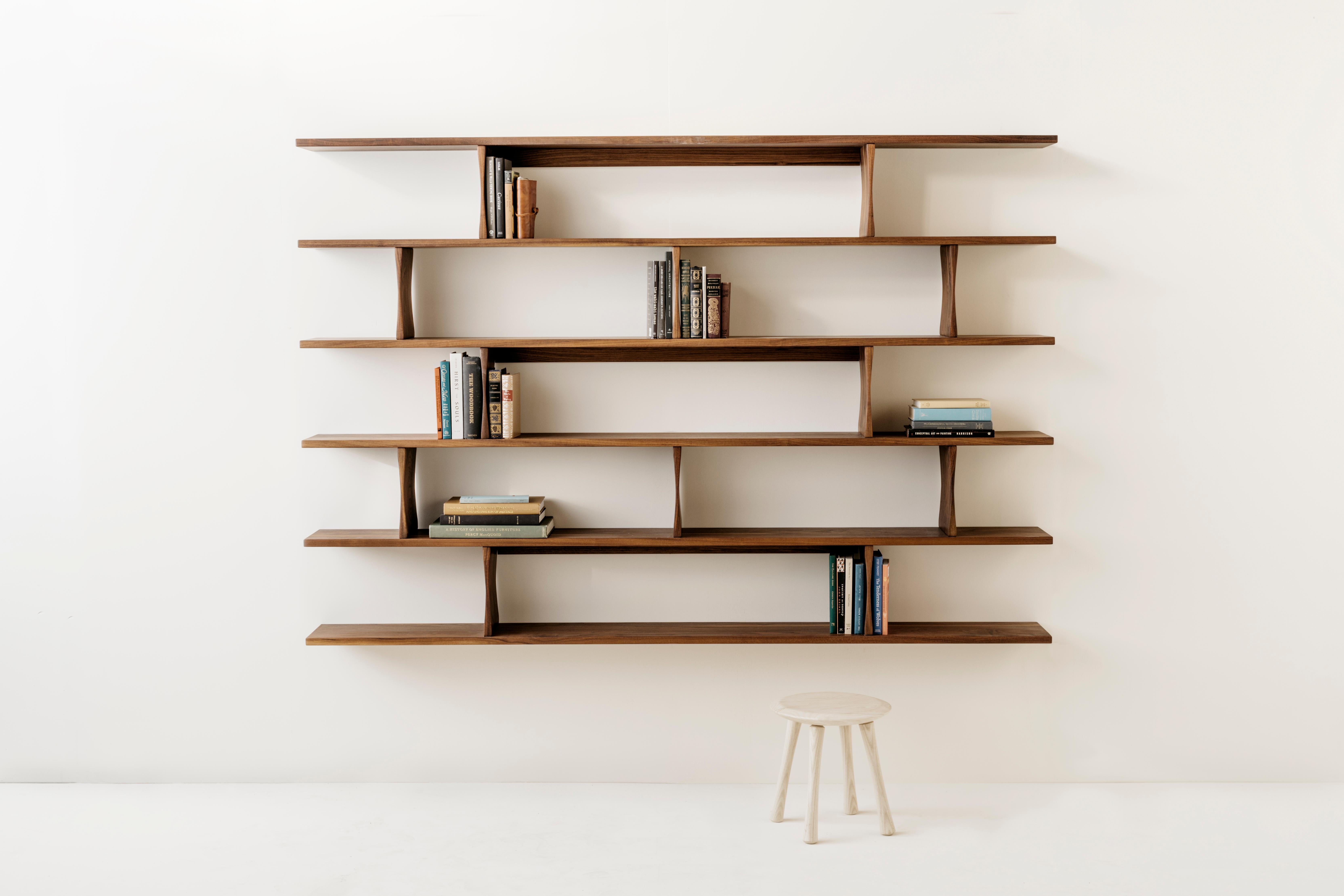 Le librerie a muro di Richard Watson sono progettate per sembrare fluttuanti sulla parete. Vengono montati con un sistema di tacchette minimale che nasconde la ferramenta di montaggio, consentendo alla forma delle mensole di non subire interruzioni.