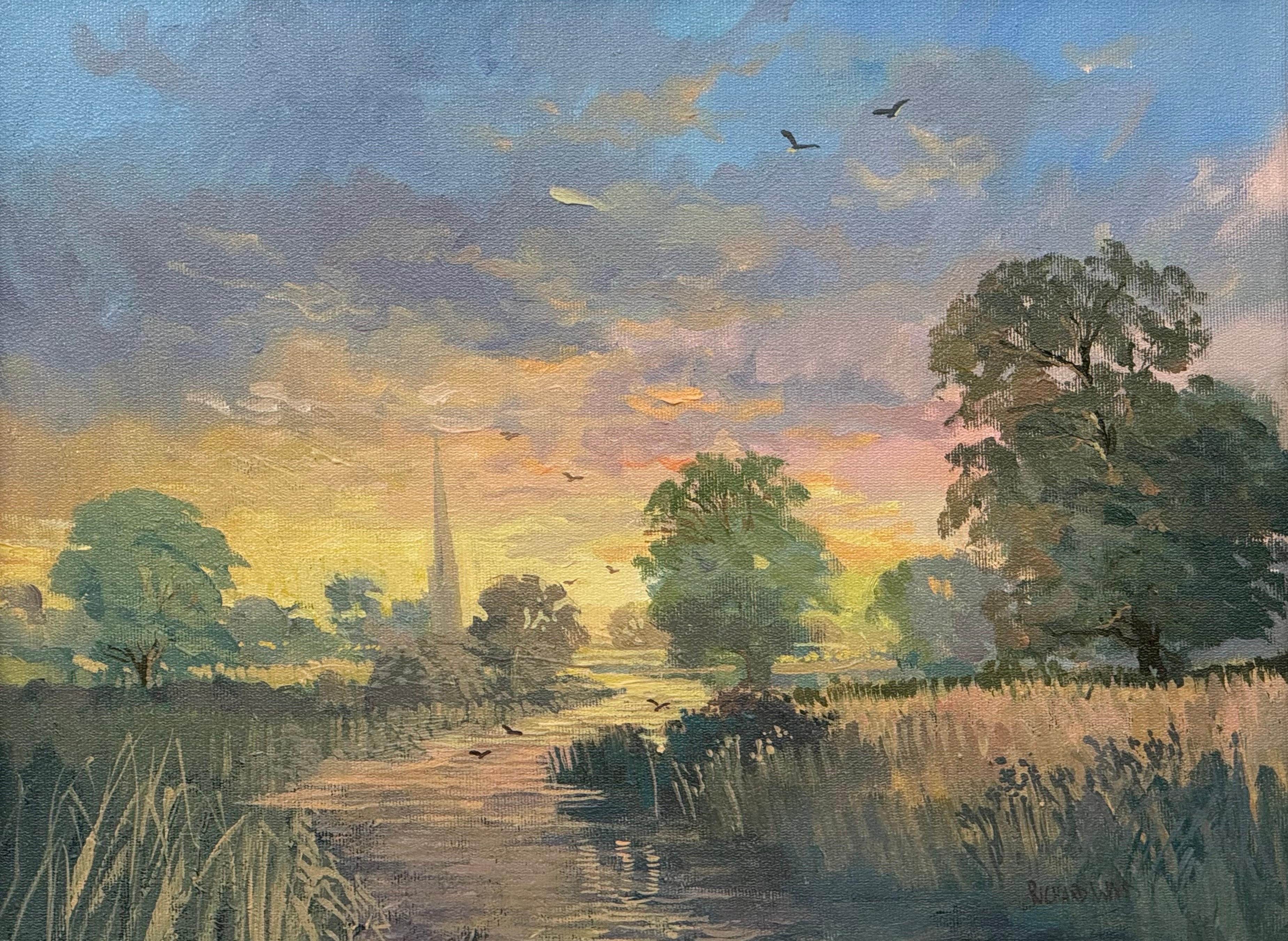 Amanecer en un pueblo junto al río en la campiña inglesa con la aguja de una iglesia y pájaros en venta 1