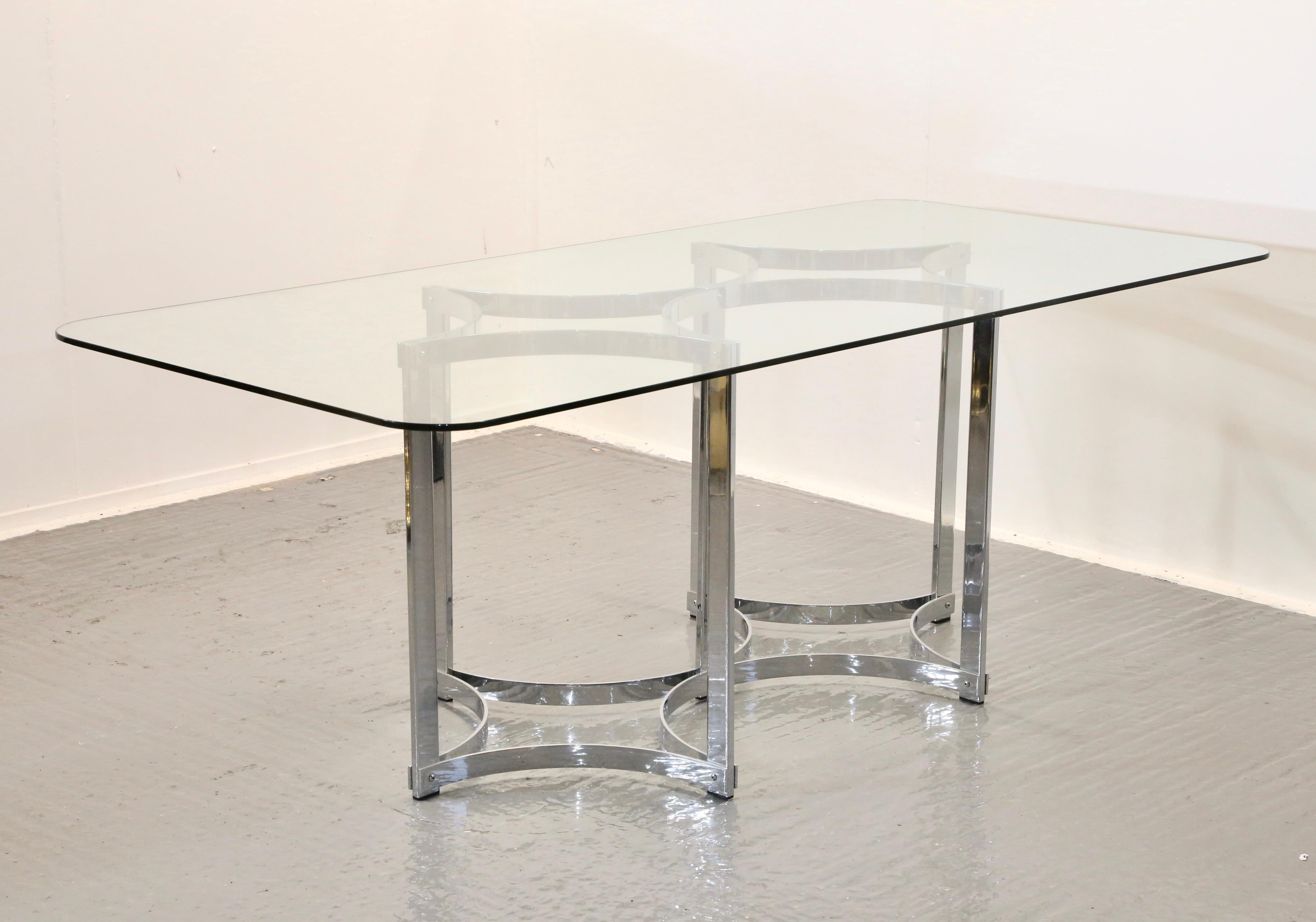 Designed by Richard Young, proprietor of high end British manufacturer Merrow Associates in 1970’s, this highly decorative dining table features a large stunning rectangular clear toughened glass top, raised on a striking chrome plated geometric