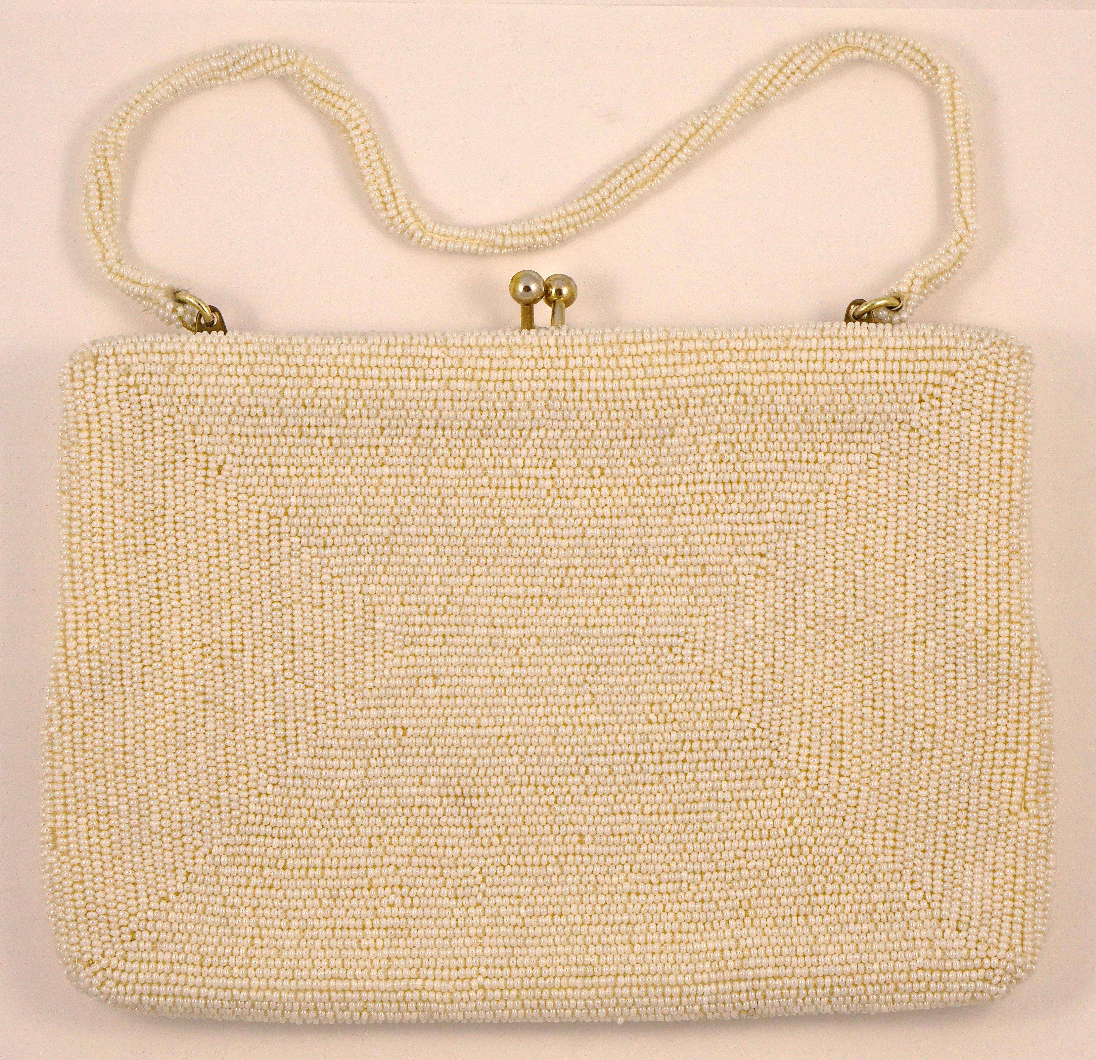 Beautiful Richere handbag hand made in Japan, embellished with ivory beads, and with a snap clasp. The bag is covered with seed beads and has a lovely pattern to the front with larger long and round beads. The beaded strap tucks neatly inside to