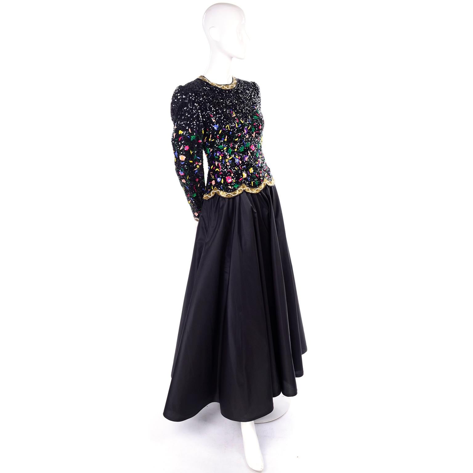 1980's Richilene New York black evening gown with a colorful embroidered, beaded & sequin bodice! The drop waist bodice has an overlayment that is covered with tiny black sequins and has a gold and white beaded trim. The sequin work has been