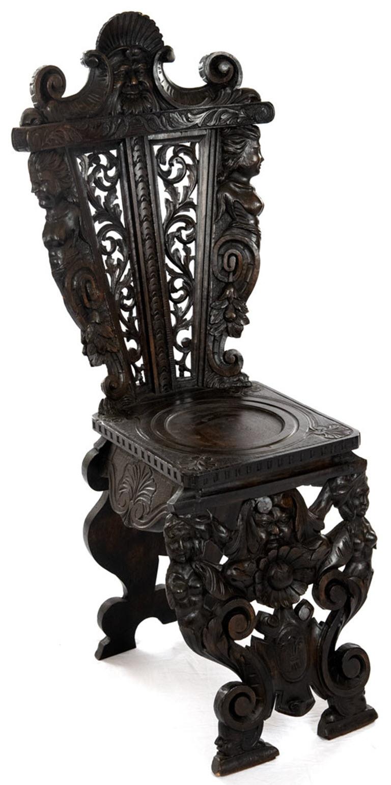 A Renaissance style, ball relief walnut chair carved with caryatids, acanthus leaves, scrolls, strap work and masks.

Measures: 46 x 21 x 21 in.