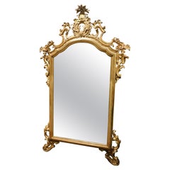 Miroir en bois richement sculpté et doré, Italie
