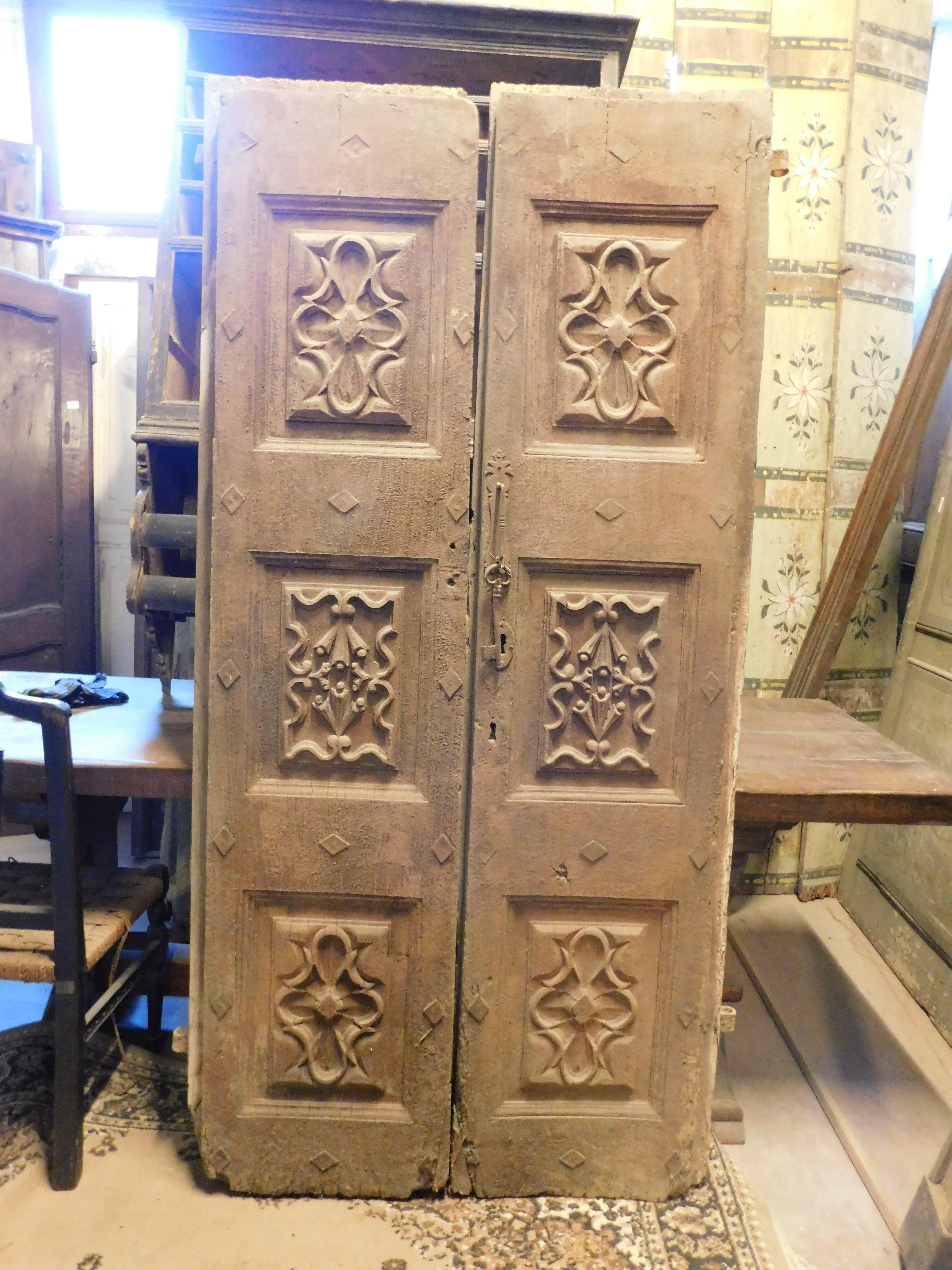 Ancient entrance door, main door in solid walnut, double-winged and richly carved in Baroque panels, built as a noble entrance to a palace in Italy, from the first half of the 18th century, smooth on the back but with a beautiful patina over the