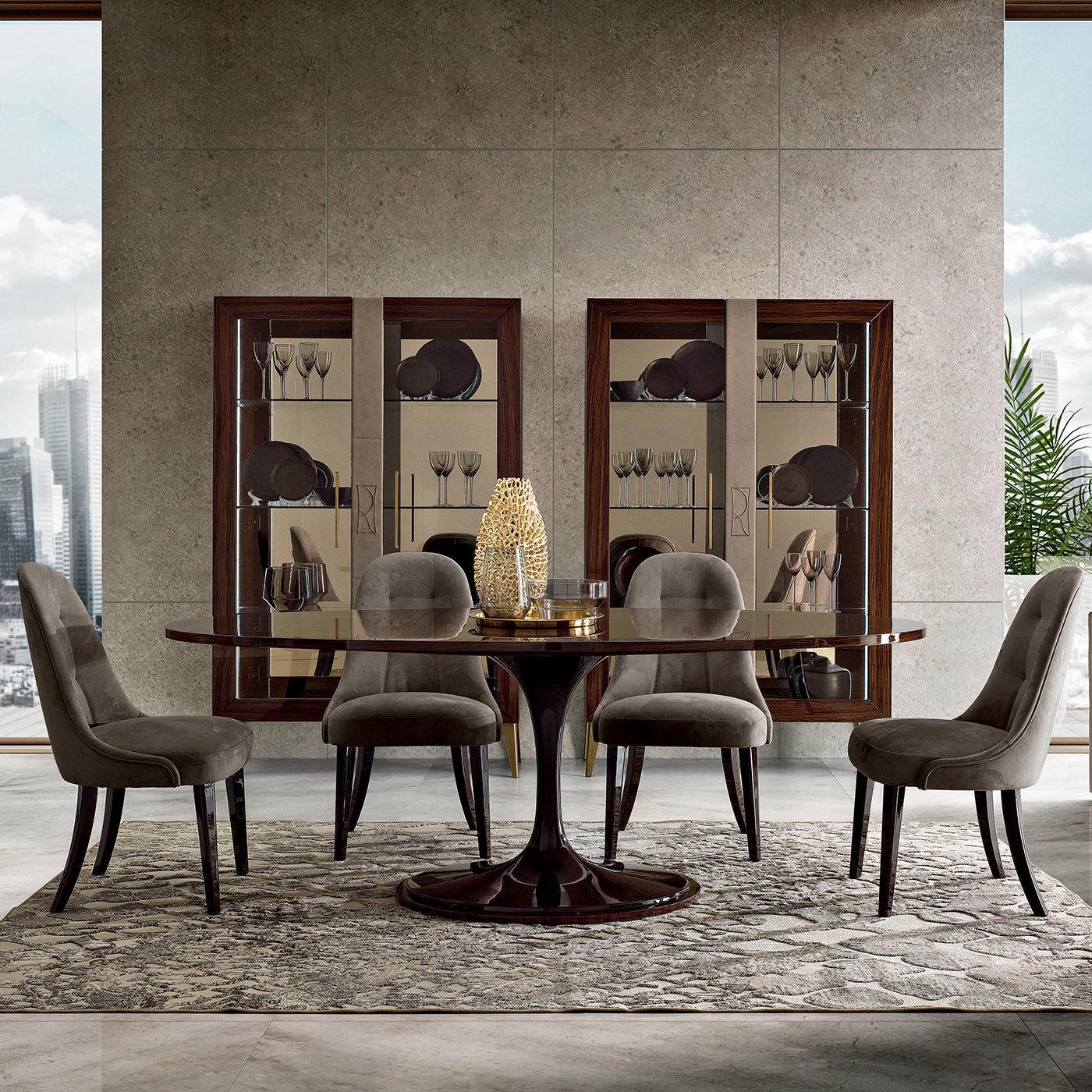 Questo tavolo ovale, che emana un fascino senza tempo, sarà la scelta perfetta per completare qualsiasi interno moderno e raffinato. L'elegante struttura a piedistallo, laccata in nero, poggia su una base ovale in palissandro, lo stesso materiale