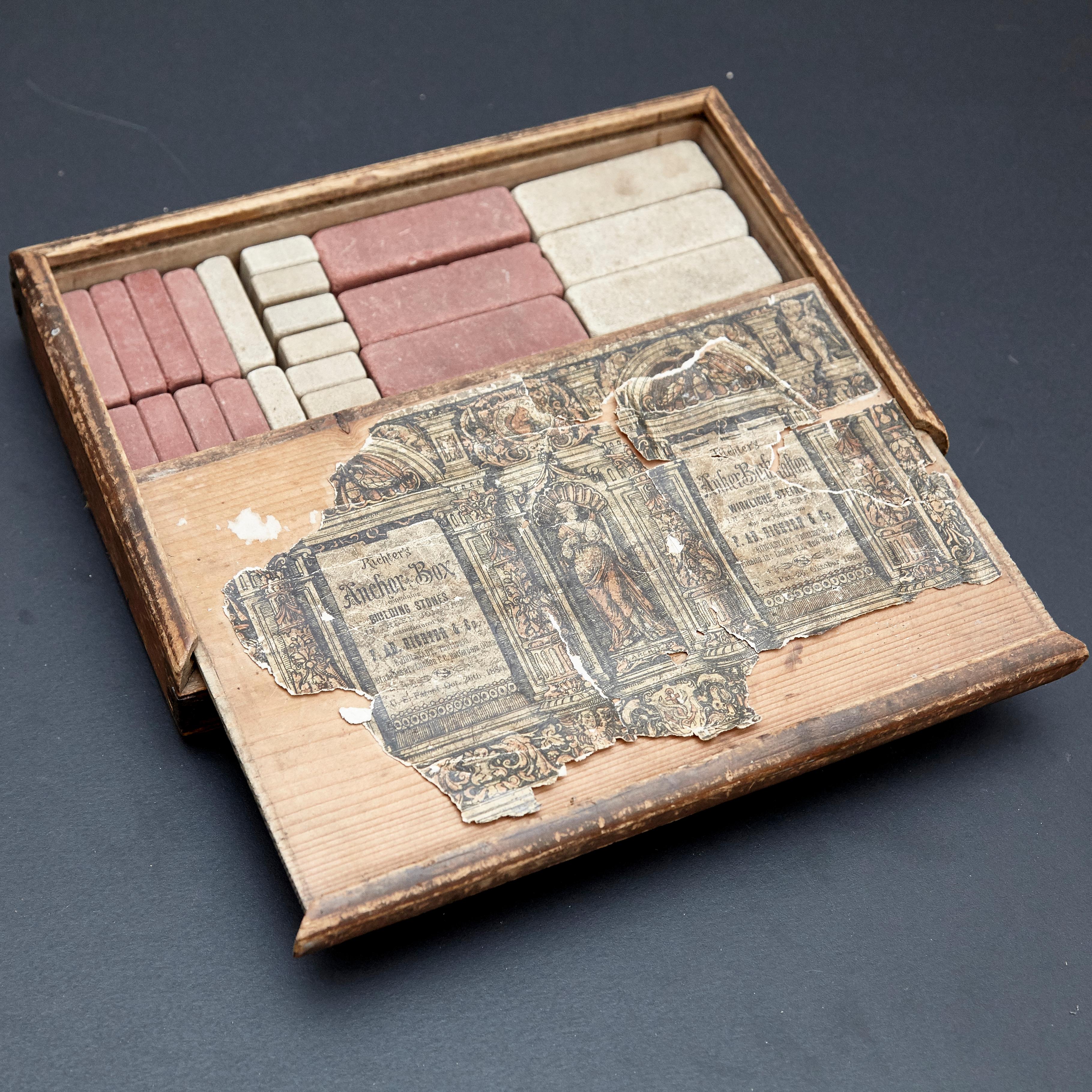 Richters German Anchor blocks building toys / Der Geschickte Baumeister 
Hergestellt in Rudolstadt, Deutschland, um 1900. 

Holzkiste mit bedruckten Papieretiketten, Steinblöcken und Anleitungsheften.

Im ursprünglichen Zustand, schwache