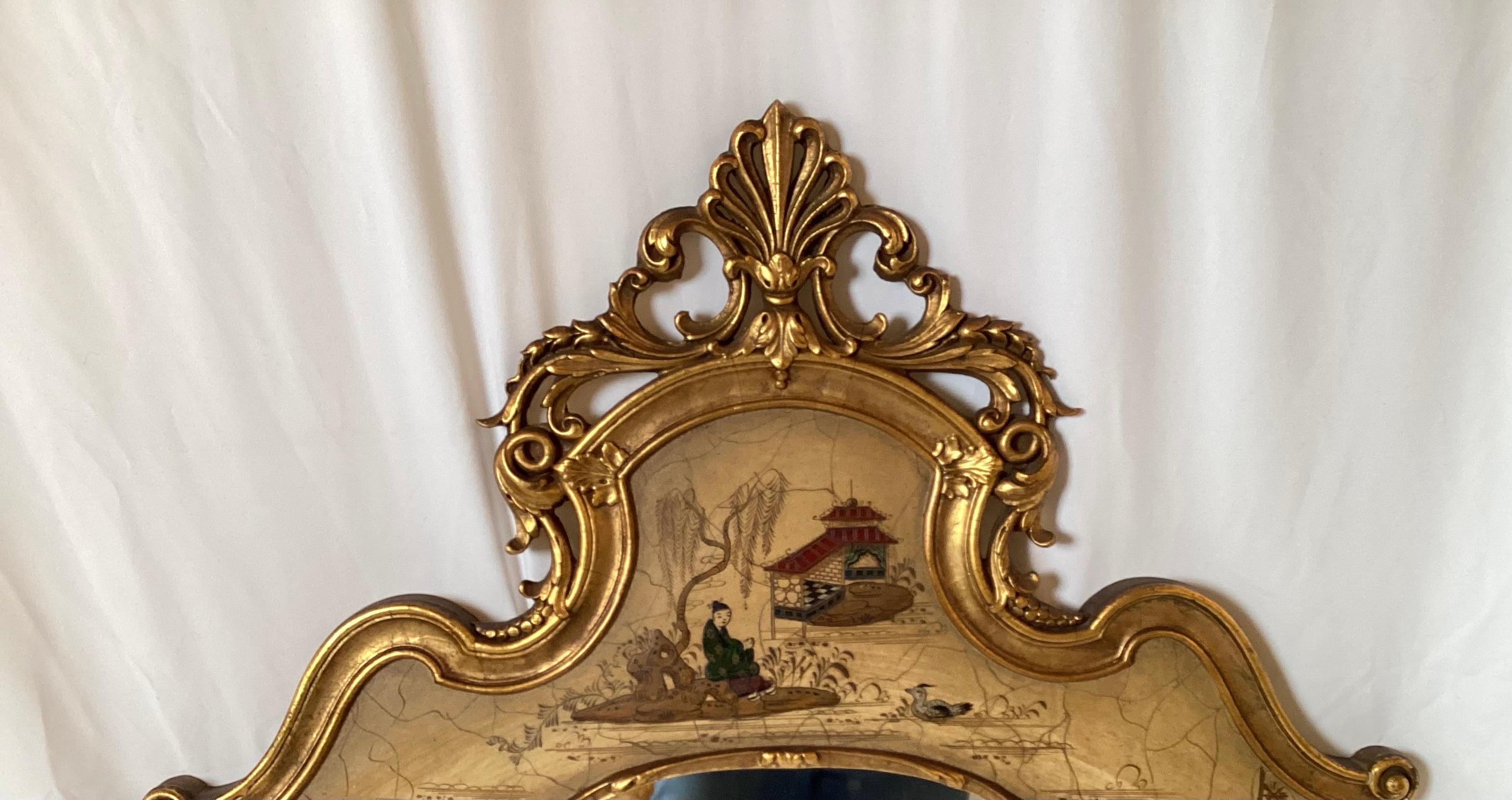 Elegant hand painted chinoiserie and gilt wall mirror. The solid wood with hand painted vanilla background with Asian themed decoration and gilt highlights. 48 inches tall, 25 inches wide