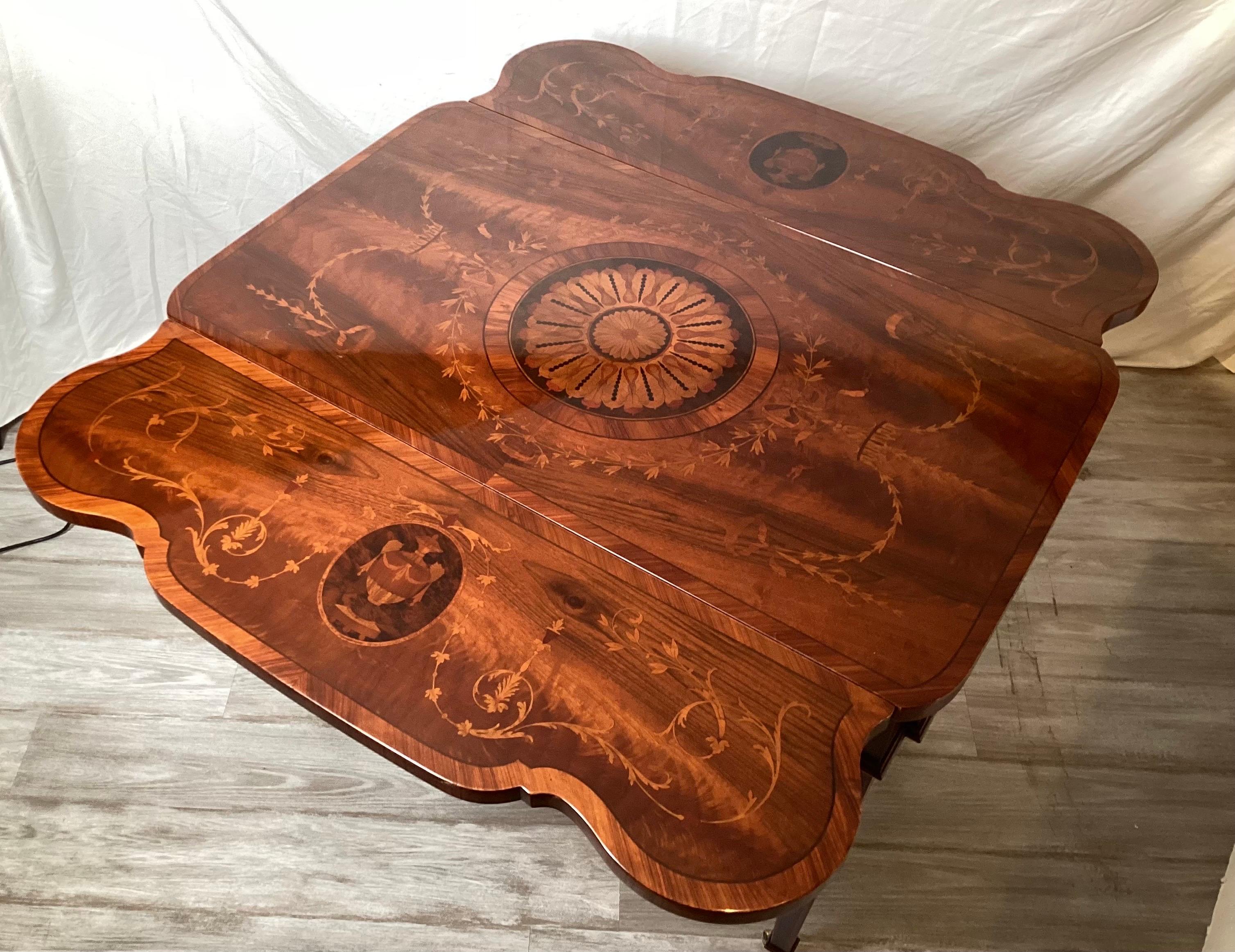 An Italian made highly inlaid Adam style drop leaf table by Rho Mobili.  The rich flame mahogany tone with inlay of tulip wood and satinwood.  The shapely drop leaves open to a full 45 inches, when leaves are down, 24 inches.  This is a generously