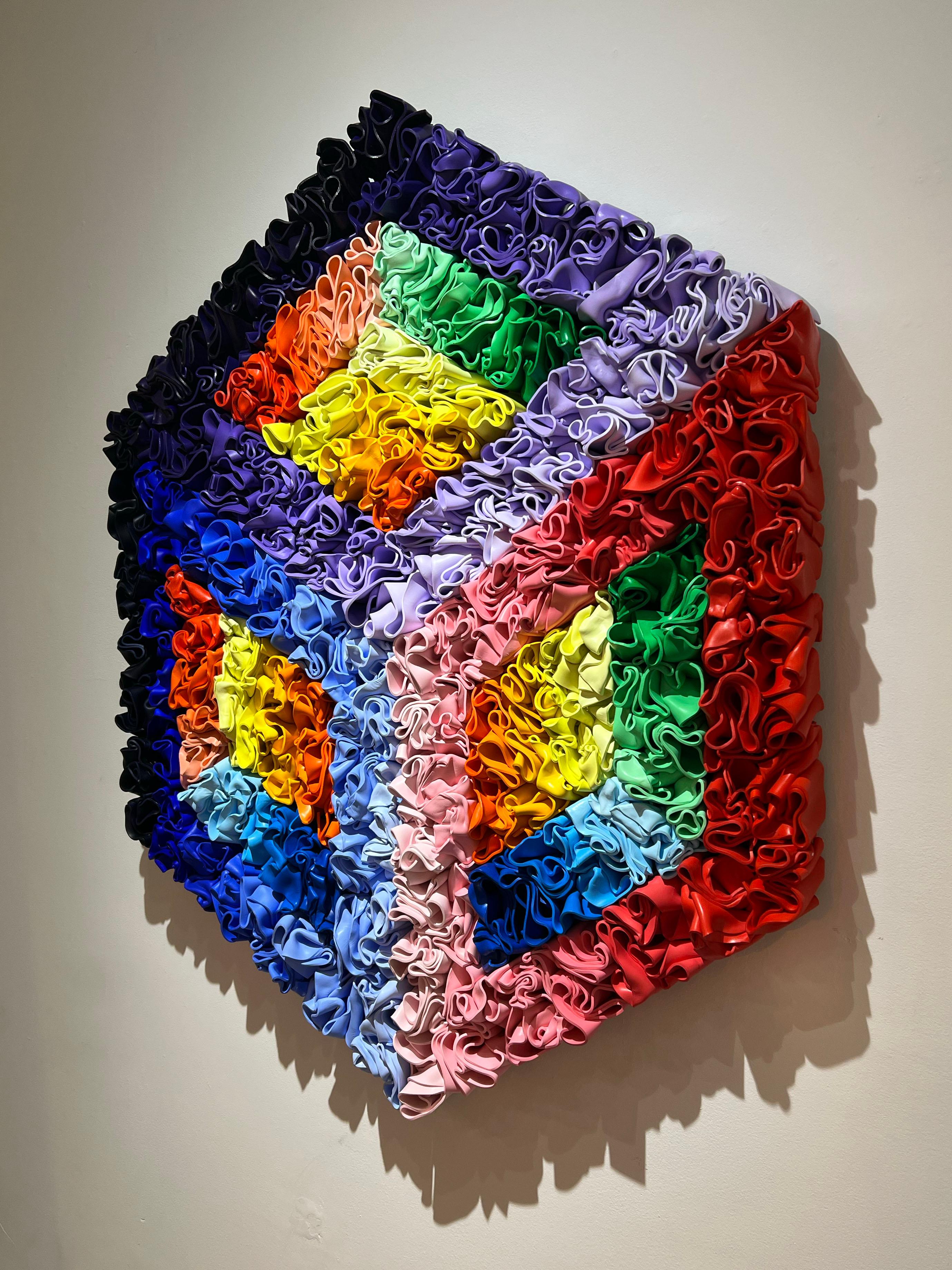 Eine abstrakte Skulptur, handgeformt mit Styrol, die eine kubistische Illusion erzeugt. Dieses Stück hat sehr lebendige Farben, die von Blau- und Lilaabstufungen über Rot und Rosa bis hin zu Orange und Gelb reichen.

Rick Lazes ist ein