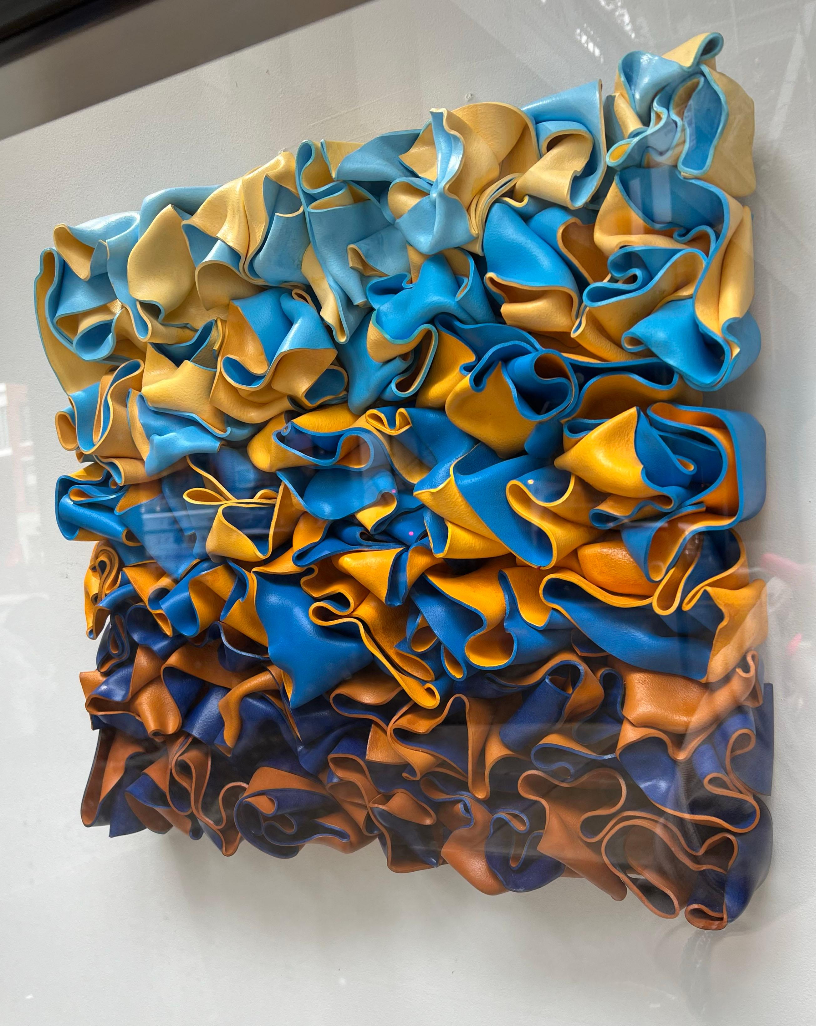 An abstract sculpture hand molded with styrene. This piece is very consist of bright yellow and blue, contrasting against each other. 

Rick Lazes is a three dimensional artist who works in a variety of media including wood, plaster, stainless