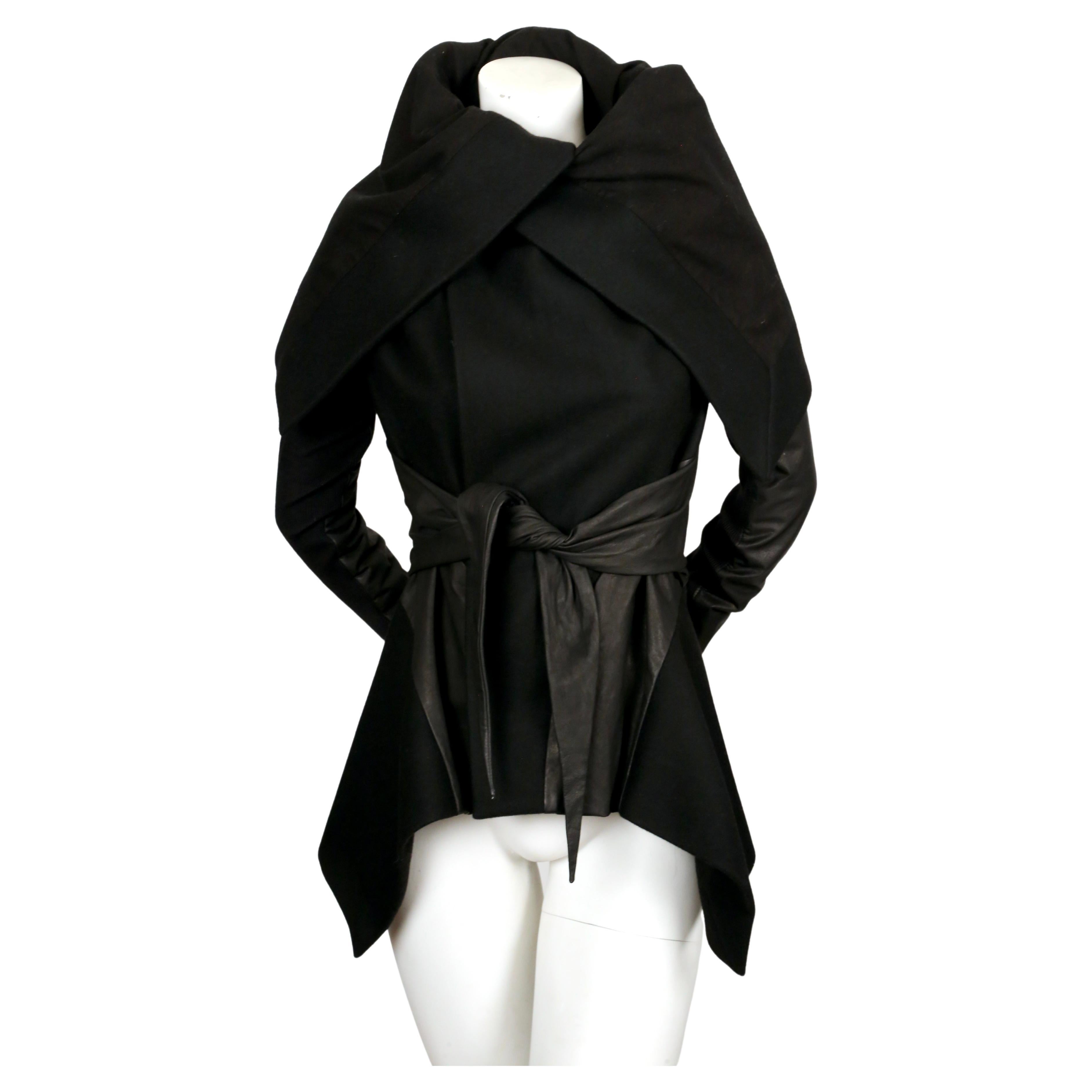 Jet-black, soft wool and cotton jacket with leather sleeves, self tie belt and asymmetrical hemline from Rick Owens. Italian size 40 which best fits a US 4 or slim 6. Coat has a very fitted shoulder and arm due to signature ribbed inserts at inside