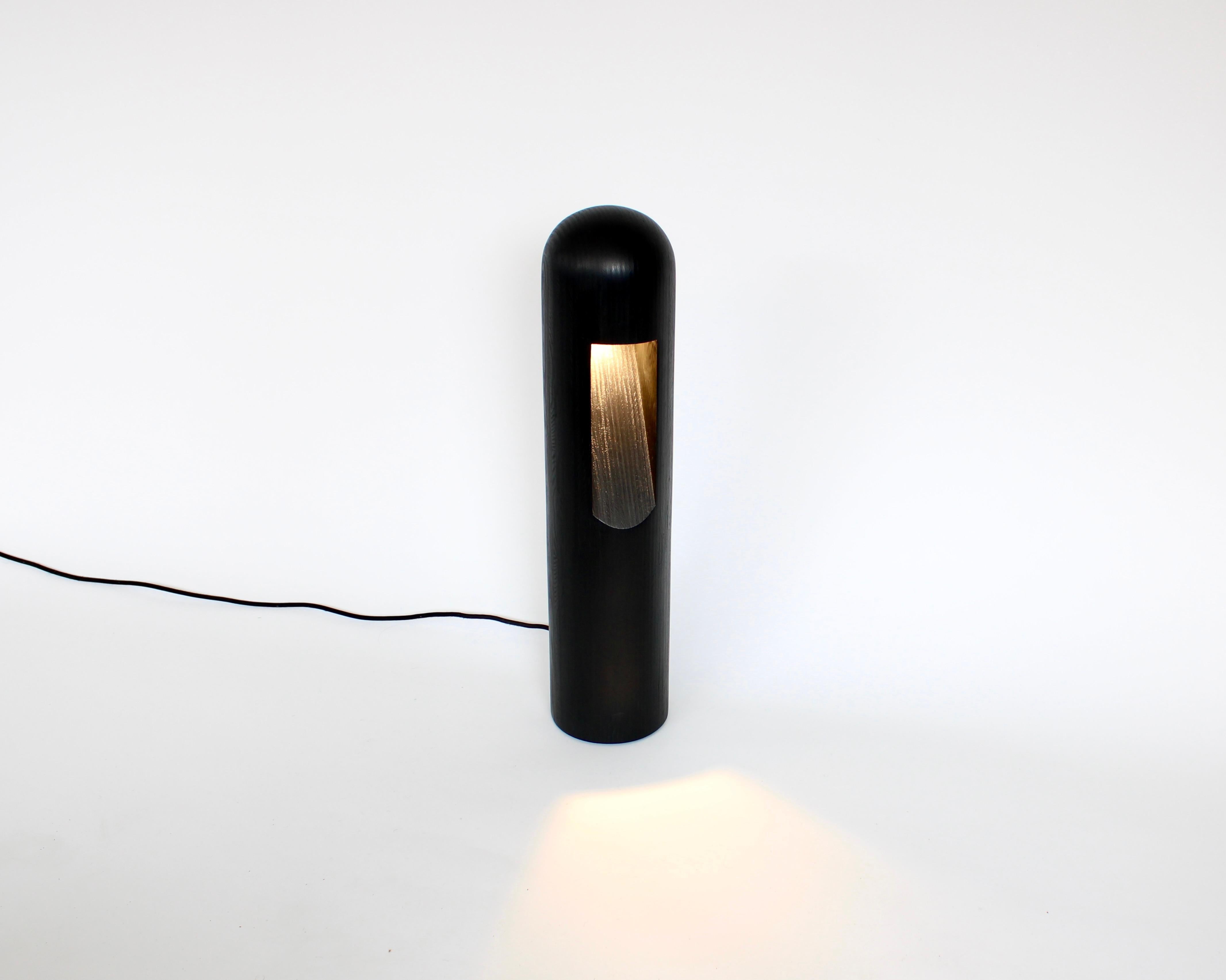 Lampe de table ou lampadaire Rick Owens en contreplaqué noir teinté avec ampoule LED. 
Ses designs/One rappellent les  archétypes. Par le choix de matériaux subtils et rares, et de formes minimales, l'œuvre d'Owens confirme son goût pour le
