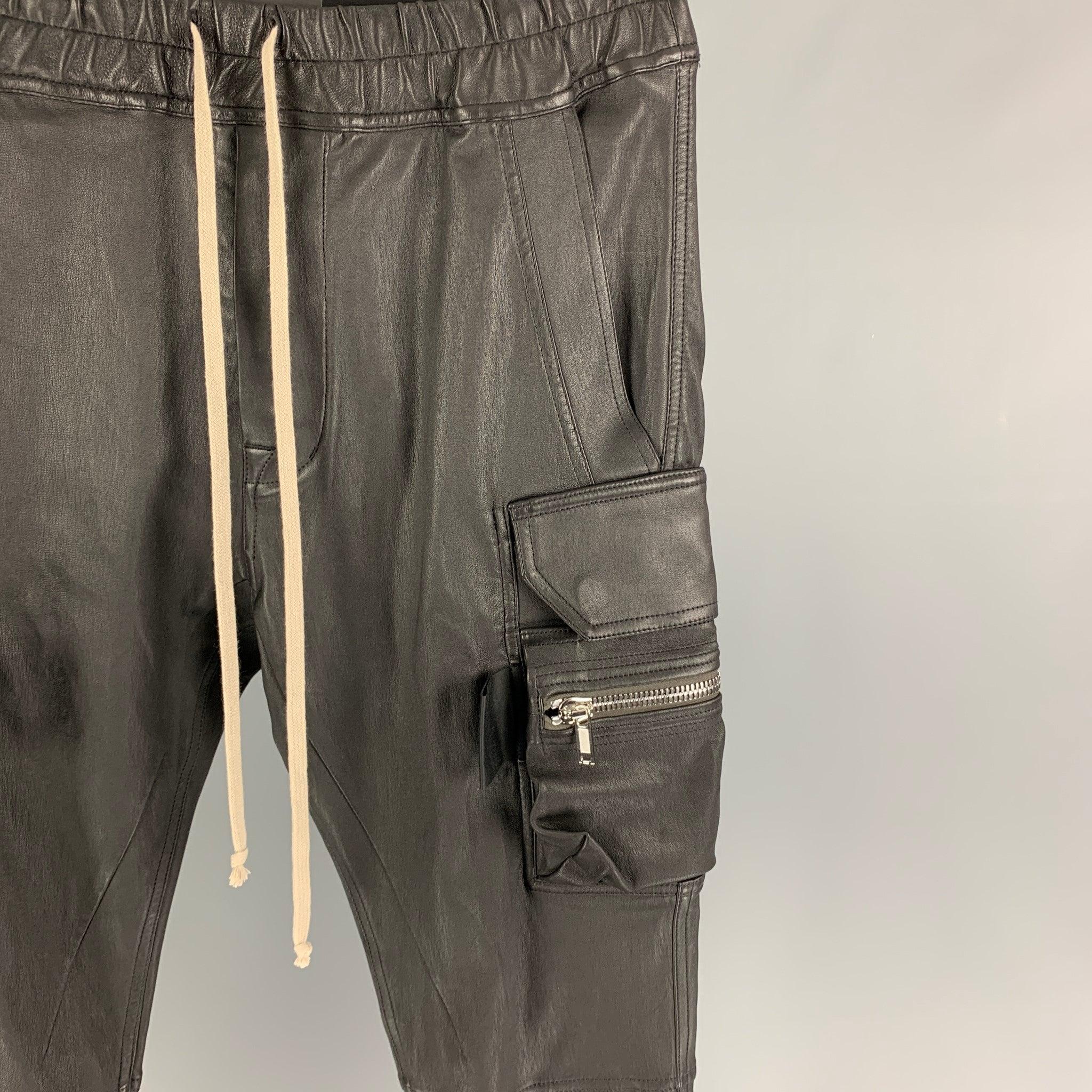 RICK OWENS Gethsemane FW 21 'Mastodon Cargo' pants comes in a black stretch leather blend featuring a slim-fit, silver tone hardware, elastic waistband, drawstring, elastic cuffs, and a snap button fly closure. Made in Italy.
New with tags.
