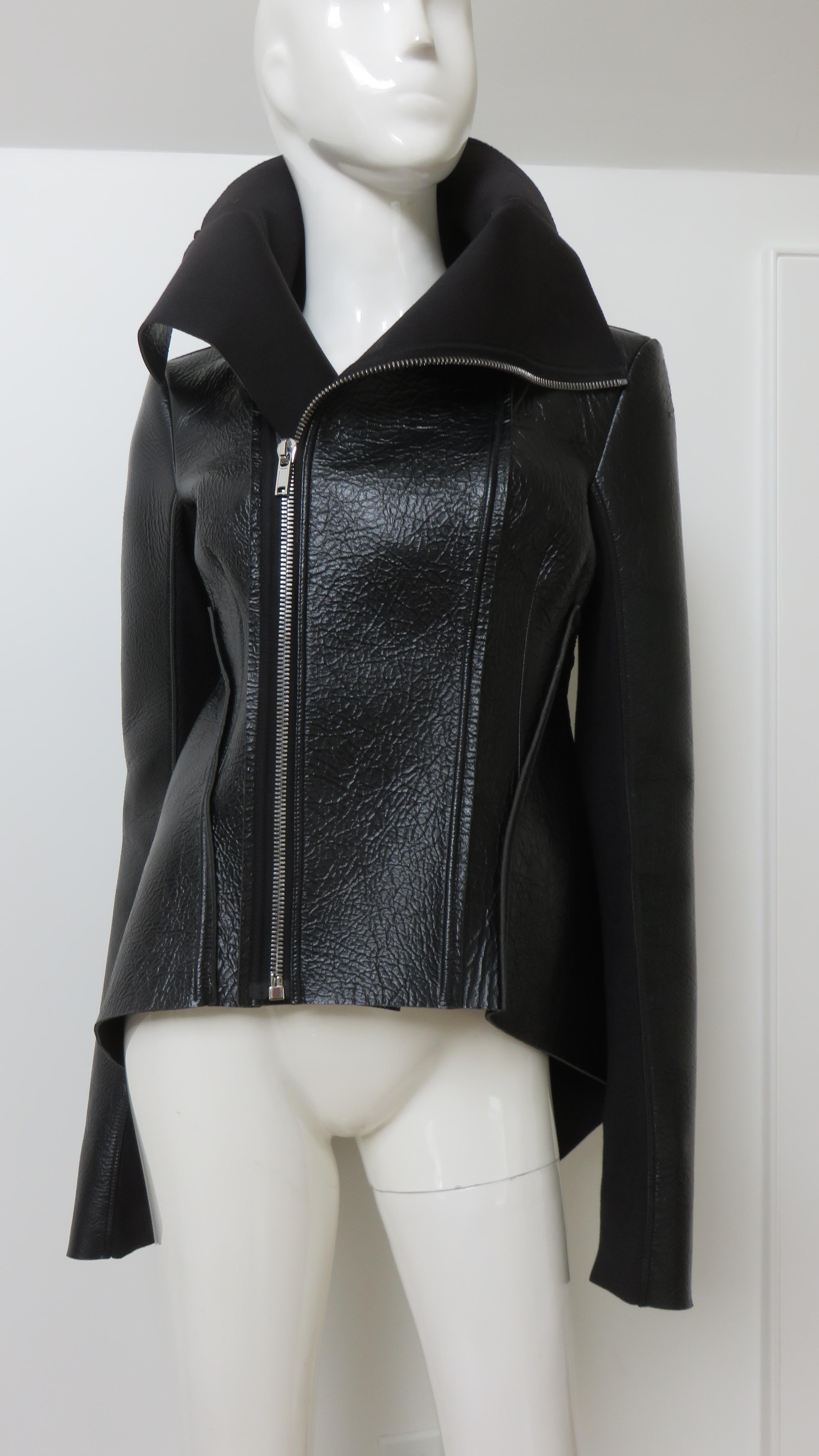 An incredible black leather jacket from Rick Owens 2015 Lilies collection.  It is fitted with a tall stand up collar, zipper front and sculptural peplum drape longer in the back.  The long sleeves have knit undersides for a flexible fit.  It is
