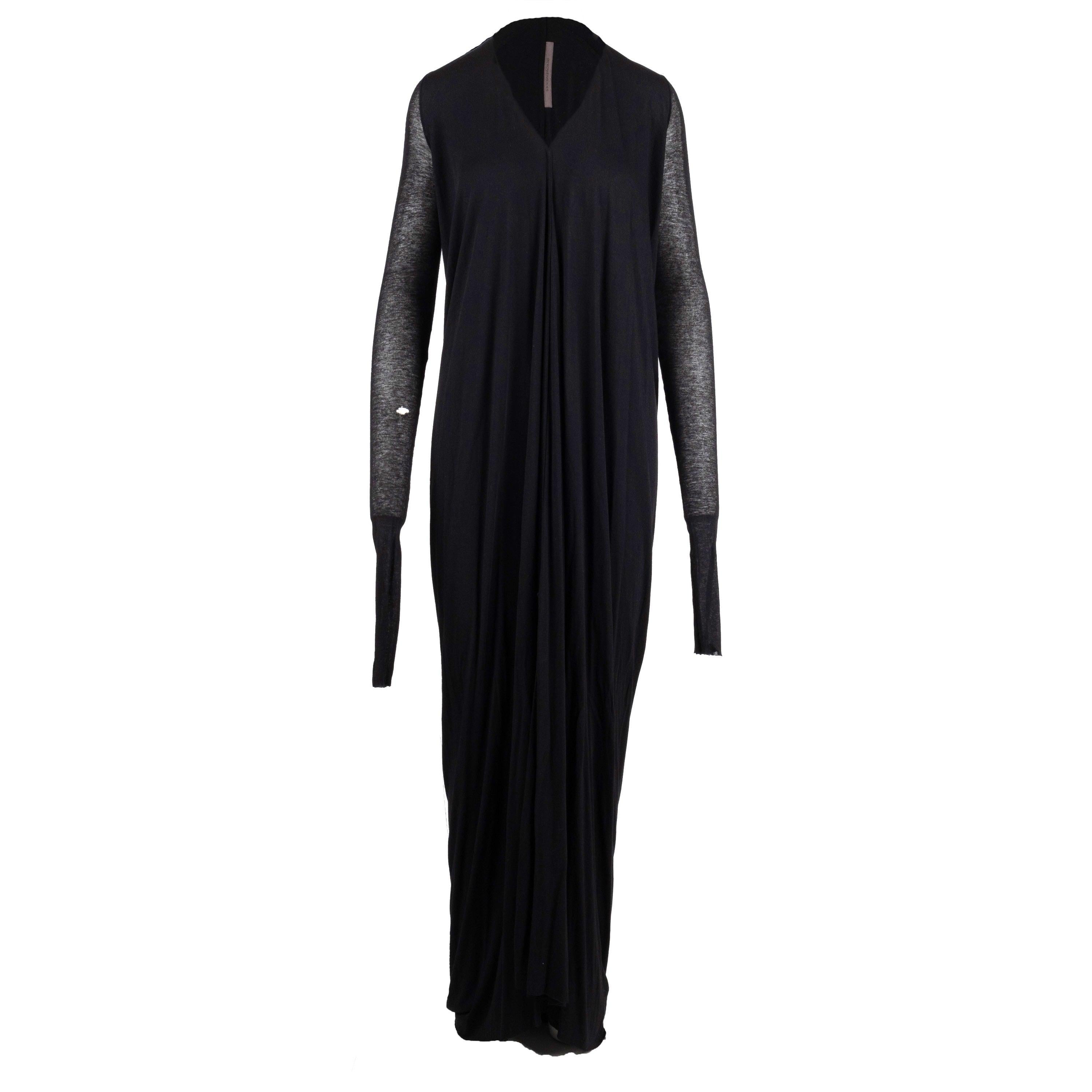 This Rick Owens Long Dress is a unique piece of fashion that stands out for its distinctive design. Crafted under the Rick Owens Lilies label, this dress is made from a knitted material in a classic black color. It features a stylish V neck, a front
