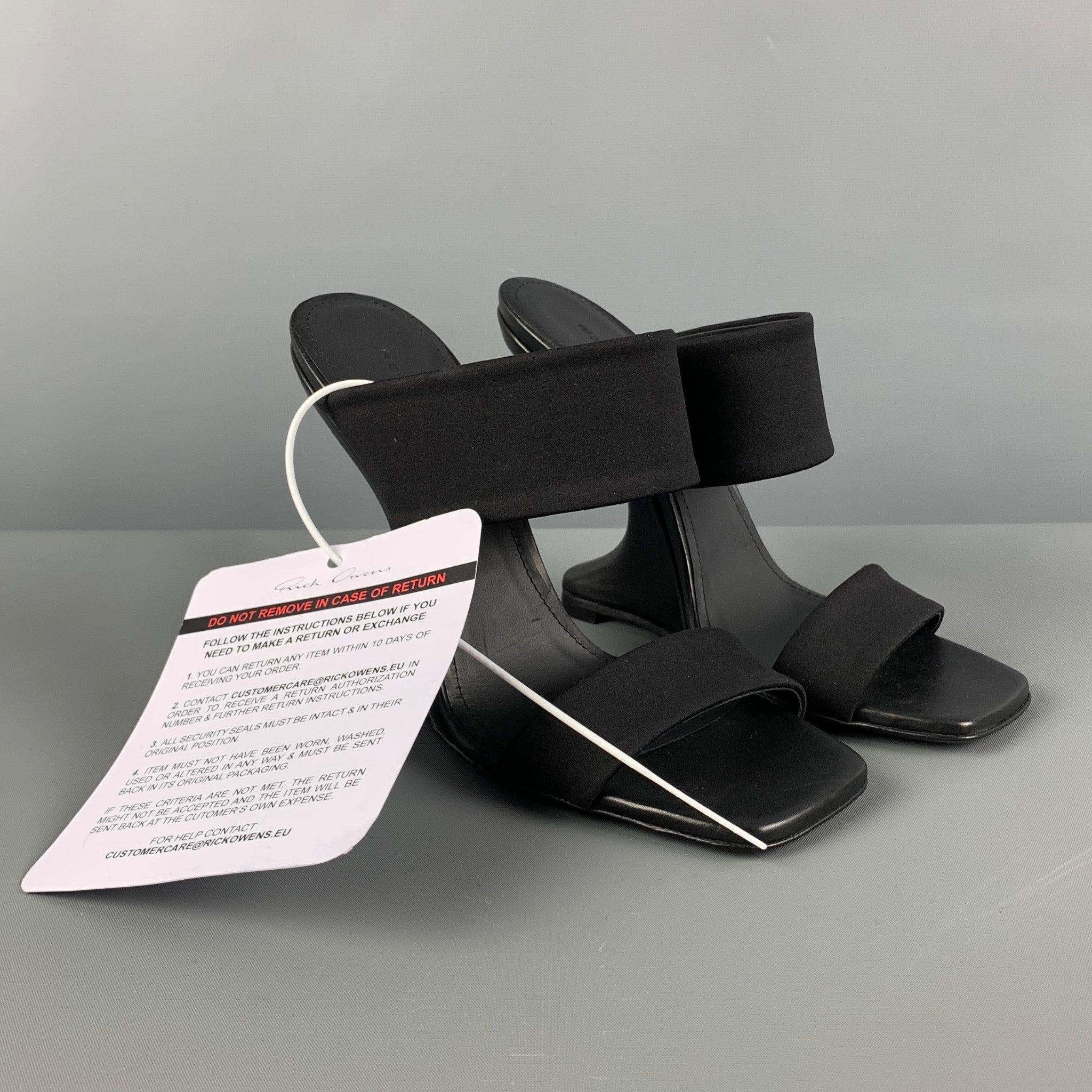 Les sandales LILIES de RICK OWENS sont présentées dans un nylon noir et présentent un bout carré, des brides épaisses sur l'empeigne et un talon compensé incurvé. Fabriquées en Italie.
Neuf avec étiquettes. 

Marqué :   37 

Mesures : 
  Talon : 5.5