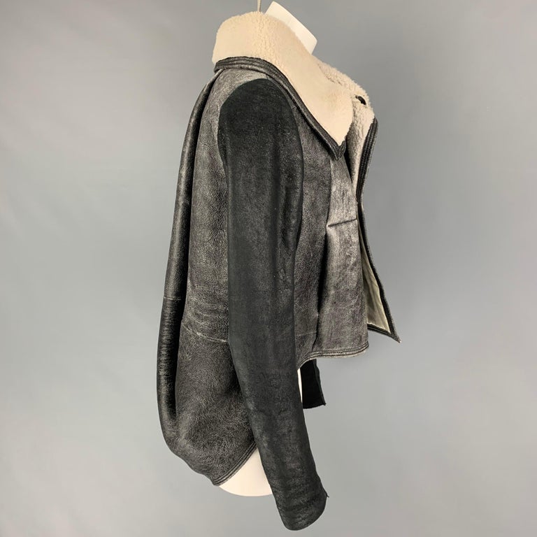 RICK OWENS coat comes in a grey distressed leather with a lamb shearling interior featuring a ribbed panel, high collar, padded back, and a asymmetrical buttoned closure. 

Very Good Pre-Owned Condition.
Marked: 44 ITA / 12 GB / 40 DE / 10