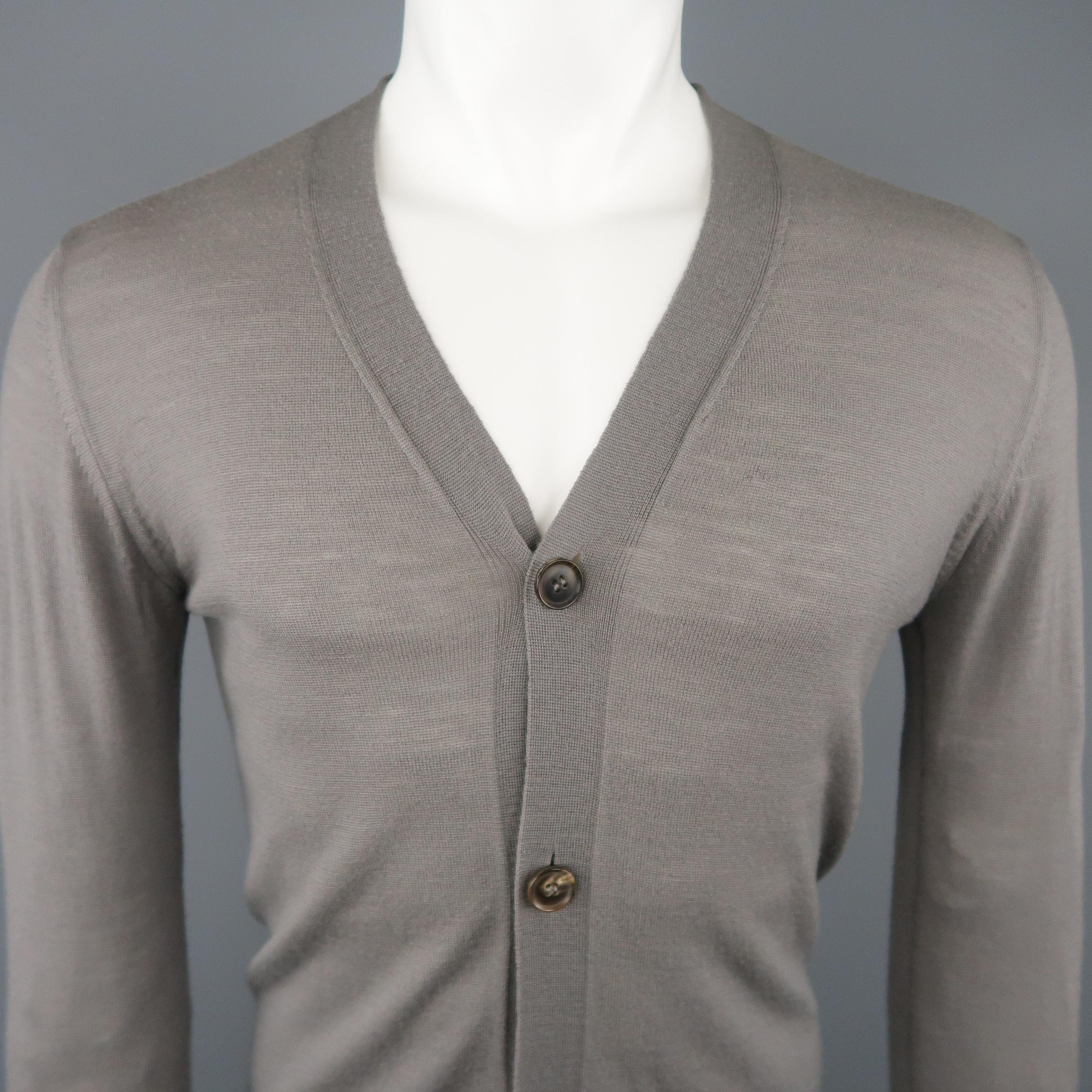 RICK OWENS cardigan comes in sheer taupe gray merino wool knit with a V neck, four button front, and curved hem. Made in Italy.
 
Excellent Pre-Owned Condition.
Marked: M
 
Measurements:
 
Shoulder: 18 in.
Chest: 40 in.
Sleeve: 28 in.
Length: 30 in.