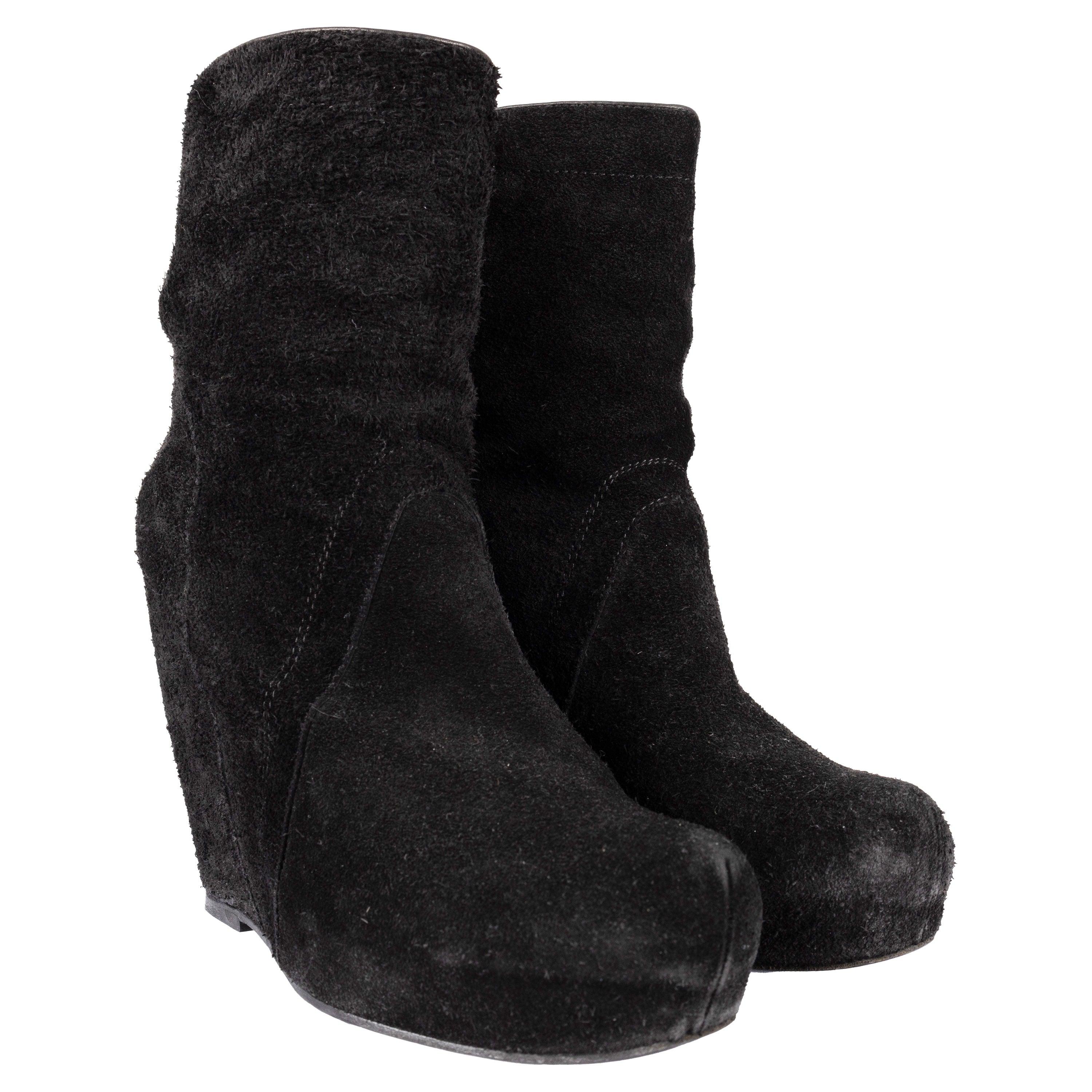 Get contemporary style with Rick Owens Suede Ankle Boots. The suede upper features a classic black hue and square-toe silhouette. The signature wedge heel with platform adds height and a modern edge to your look. 
 Remarks: There are pilling on the