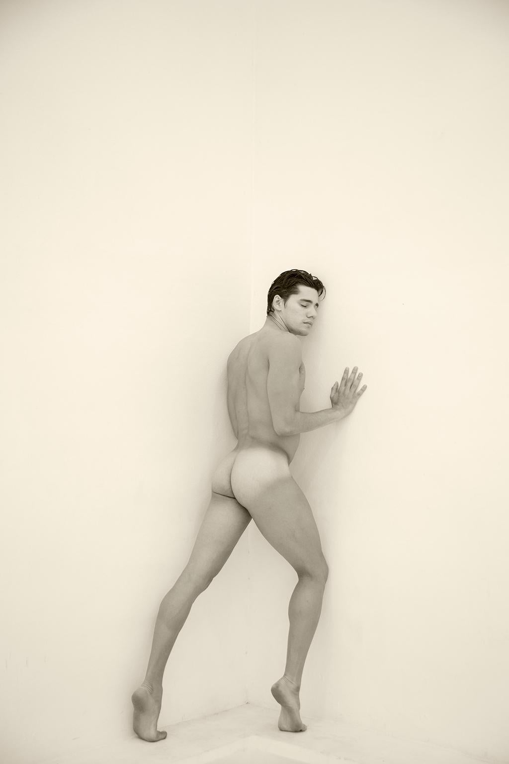 Ricky Cohete Nude Photograph - Man against wall, One. Motion Series. Male Nude Sepia Photograph