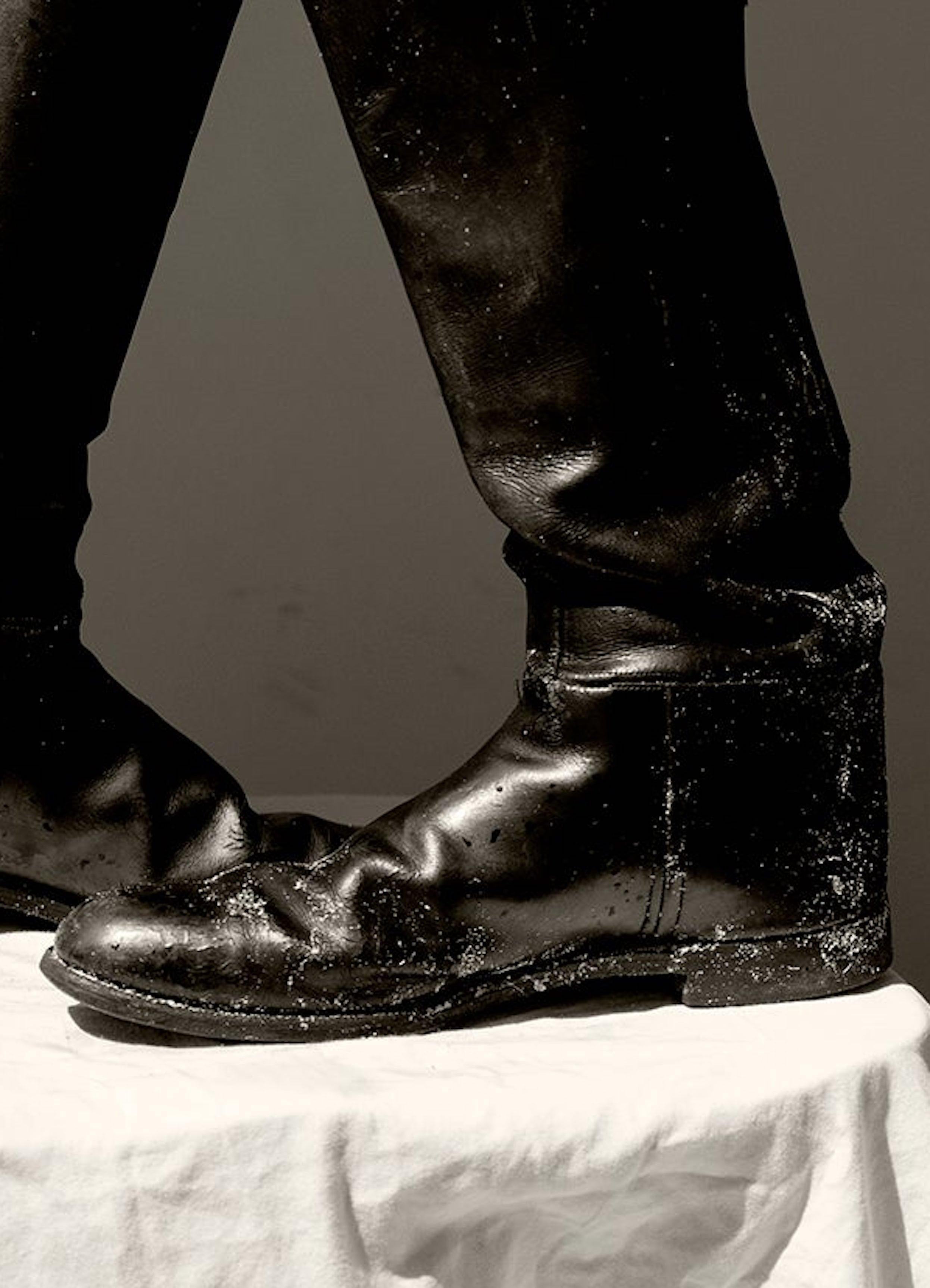 Hombres y Botas.  Fotografía sepia de edición limitada - Nude Photograph Negro de Ricky Cohete