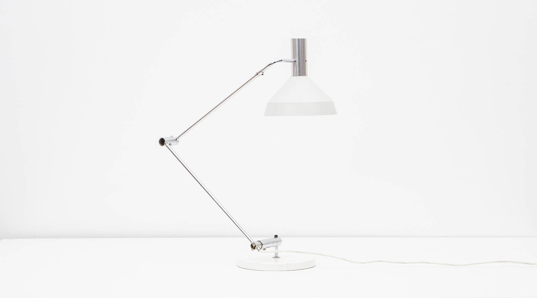 The double pivoting table lamp designed by Rico Baltensweiler can be posed in various positions and comes in white lacquered aluminum and metal, the adjustable pole is chromium-plated steel. Manufactured by Baltensweiler AG. We have various examples