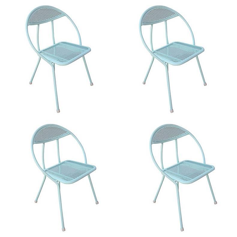 This Mid-Century Modern outdoor dining set by Rid-Jid features four rounded back folding chairs and a circular dining table with a hole in the center for an umbrella. The table and chairs are made of a combination of mesh and tubular steel all have