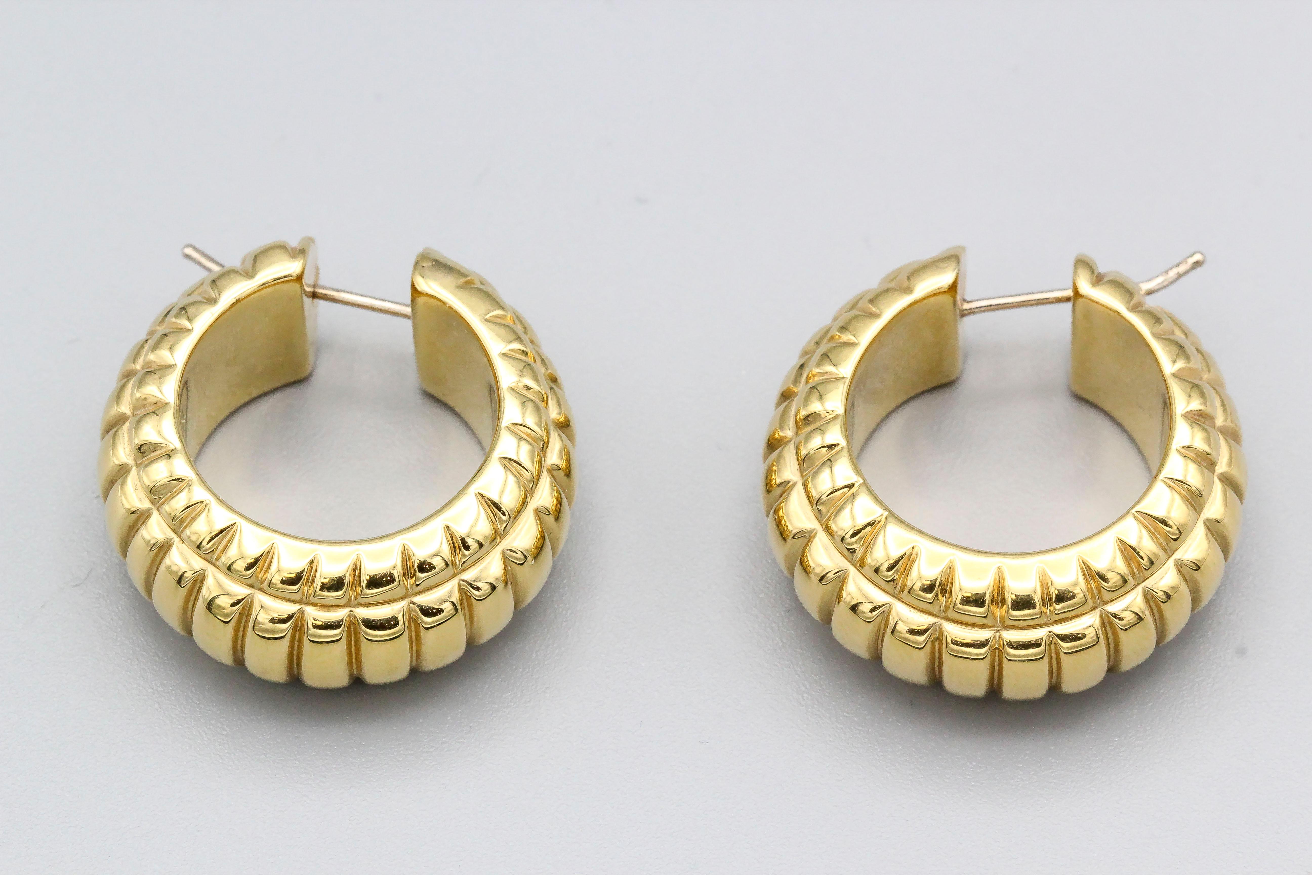 Elegant 18K yellow gold ridged hoop earrings.

Hallmarks: 750.
