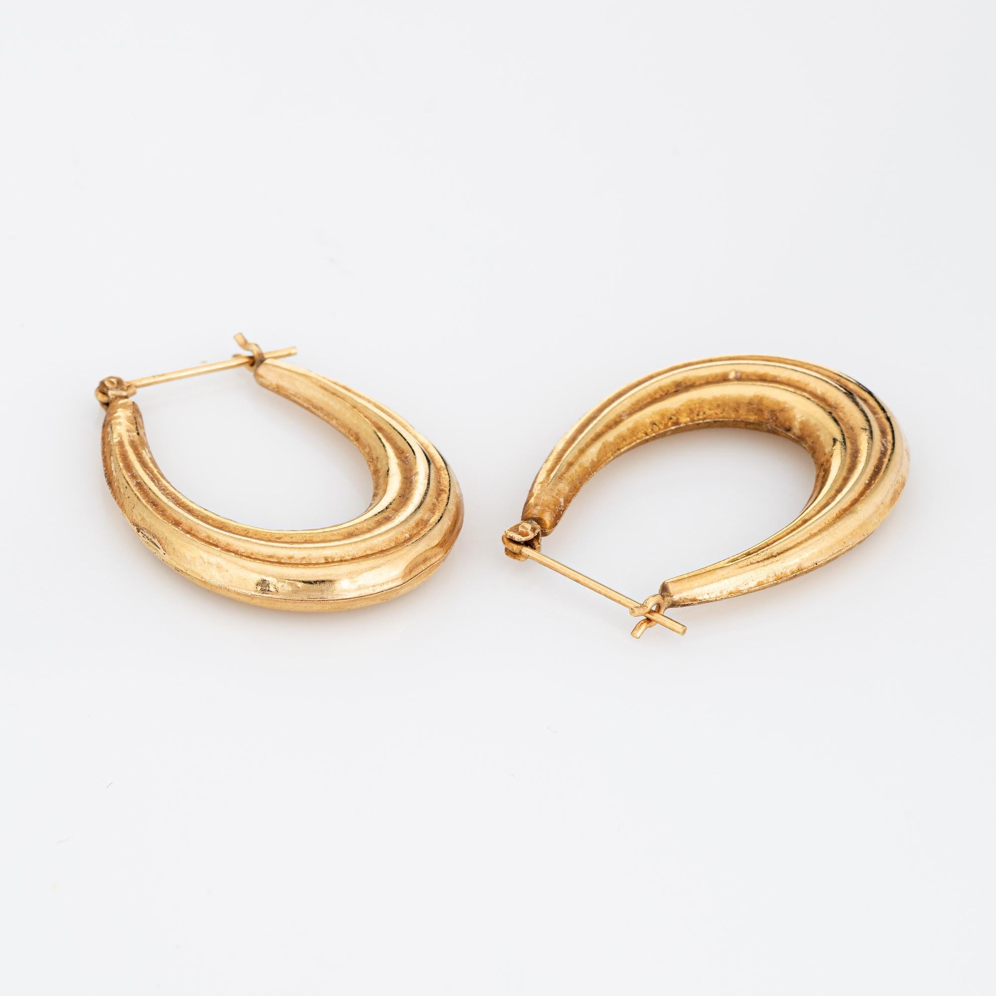 Fine detailed pair of oval hoop earrings crafted in 14k yellow gold (circa 1980s). 

The stylish earrings feature a ridged design. The hollow earrings offer a lightweight feel for a comfortable fit on the earlobe. The earrings are fitted with post