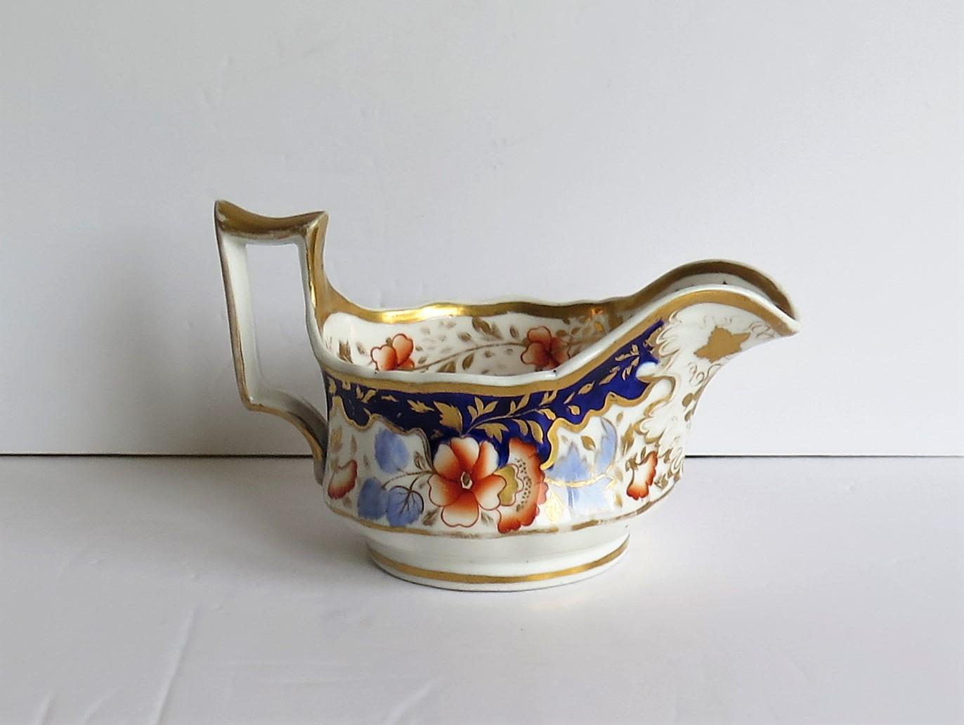 This is a very decorative, porcelain milk jug or creamer in the early Grecian shape, made by John and William Ridgway, of Shelton, Hanley, Staffordshire Potteries, England, dating to the Late Georgian Regency period of the early 19th century, circa